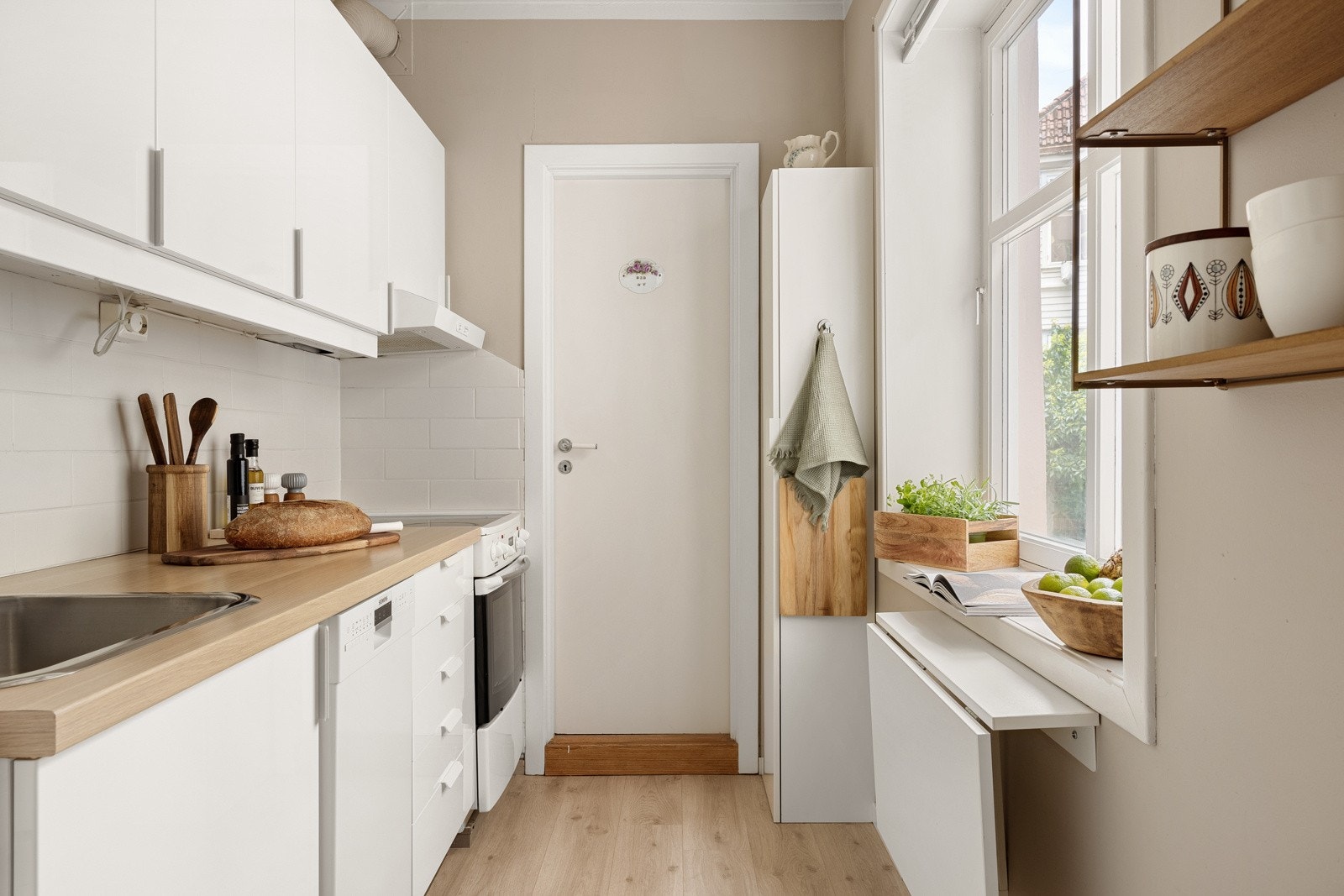 Kjøkkeninnredningen består av slette fronter og laminat benkeplate med nedfelt vask av stål. Galleribilde