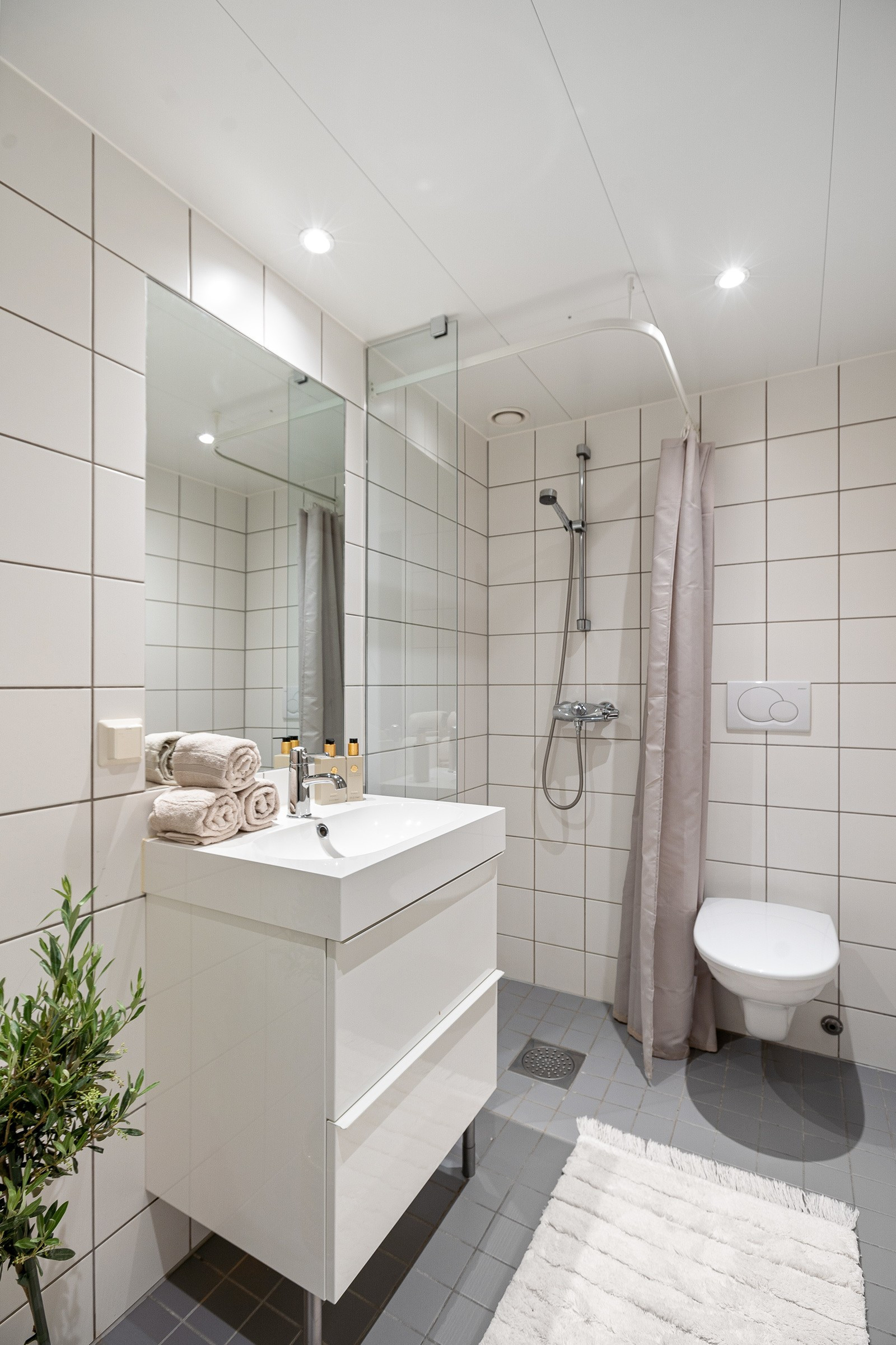 Badet er flislagt og har opplegg for vaskemaskin