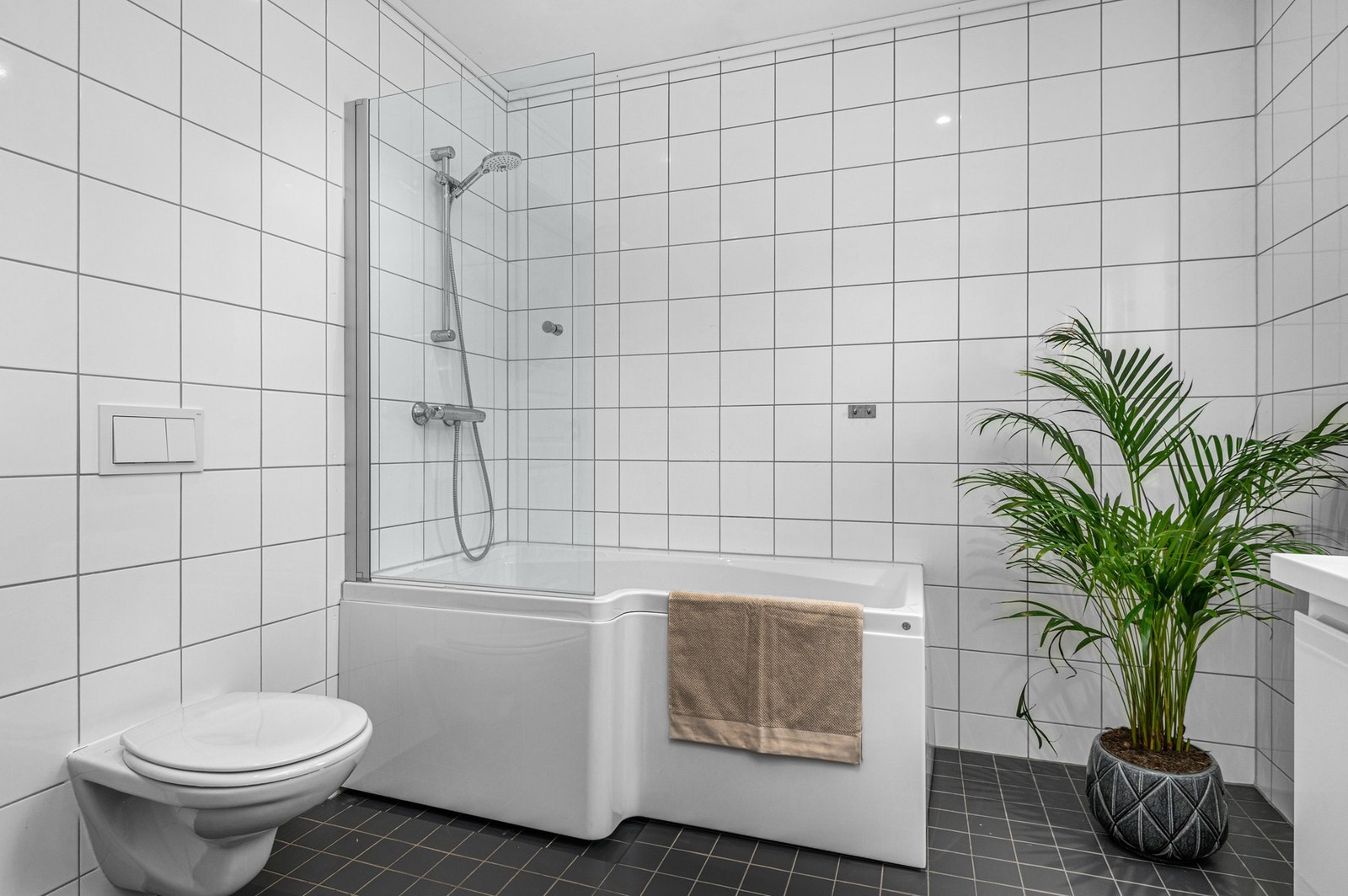 Vegghengt wc og dushjørne med badekar. Varme i gulv og downlights. Galleribilde