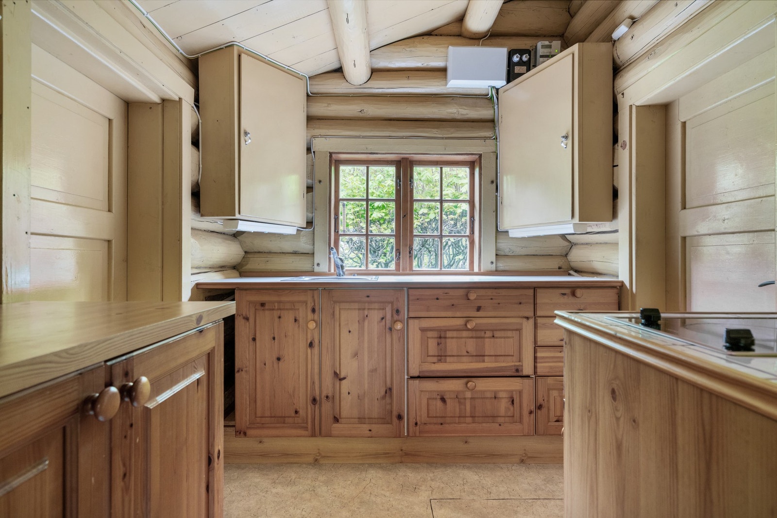 Lyst kjøkken med furudører på underskap og finerfronter på overskap. Galleribilde