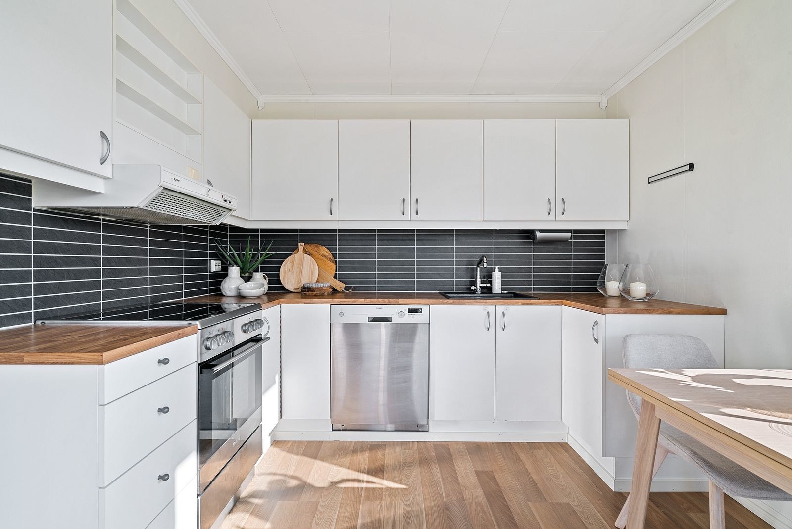 Kjøkken med folierte fronter og skrog, laminat benkeplate med benkebeslag i kompositt. Galleribilde