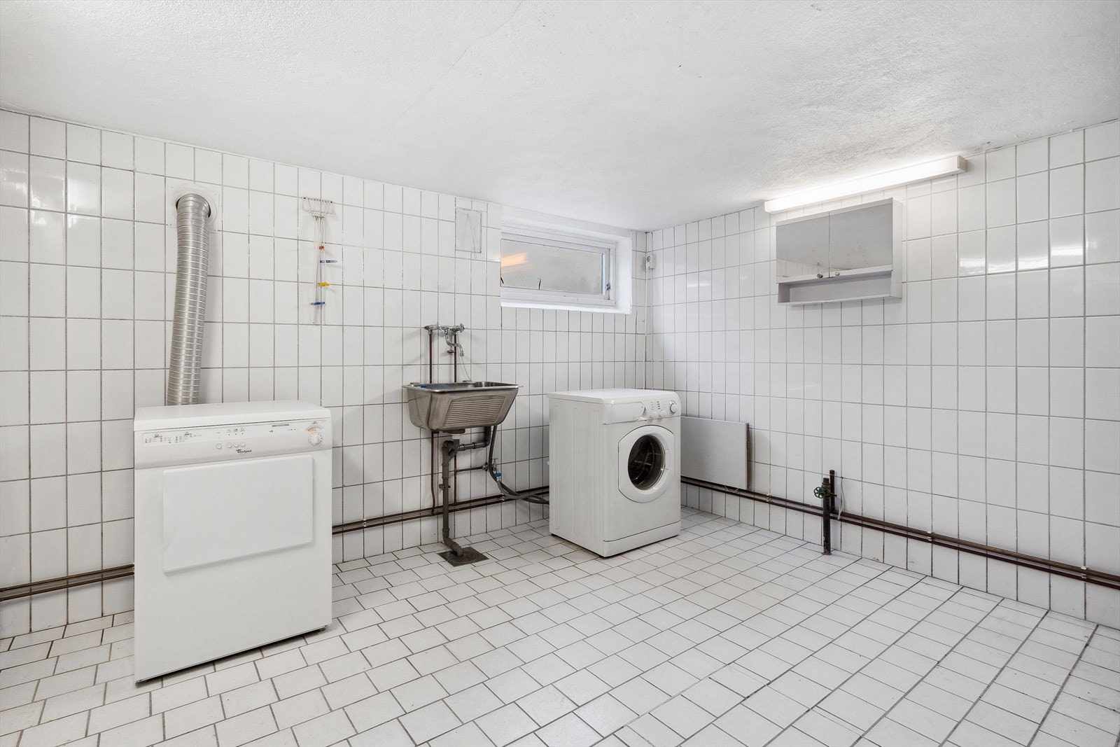 Vaskerommet inneholder opplegg for vaskemaskin, utslagsvask og enkel dusjplass. I kjelleren finnes også flere boder. Galleribilde