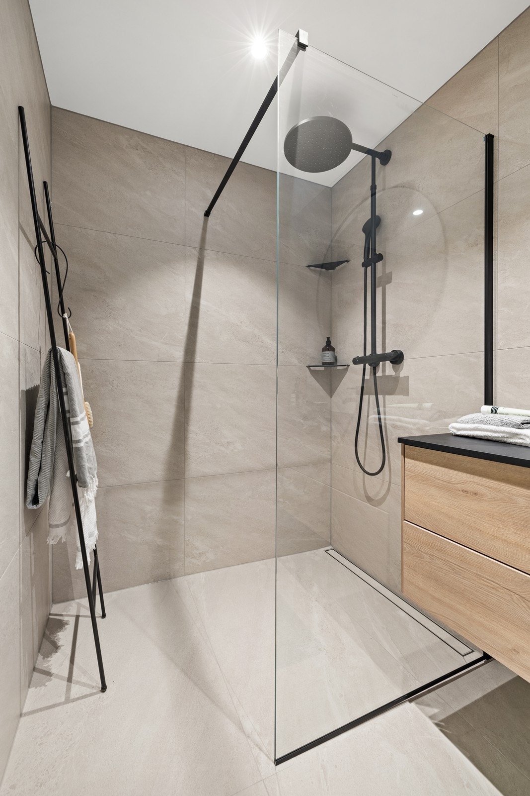 Rommet er innredet med dusjnisje, servant nedsenket i innredning og vegghengt toalett. Galleribilde