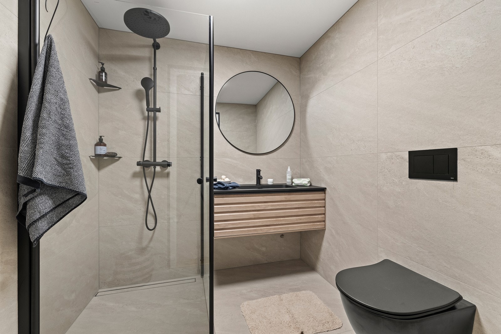 Baderom er innredet med dusjhjørne med innfellbare glassdører, servant nedsenket i innredning og vegghengt toalett. Galleribilde