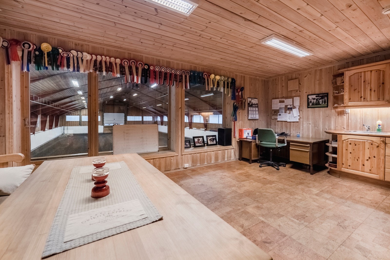 Fellesrom med store vinduer ut til innvendig ridehall Galleribilde