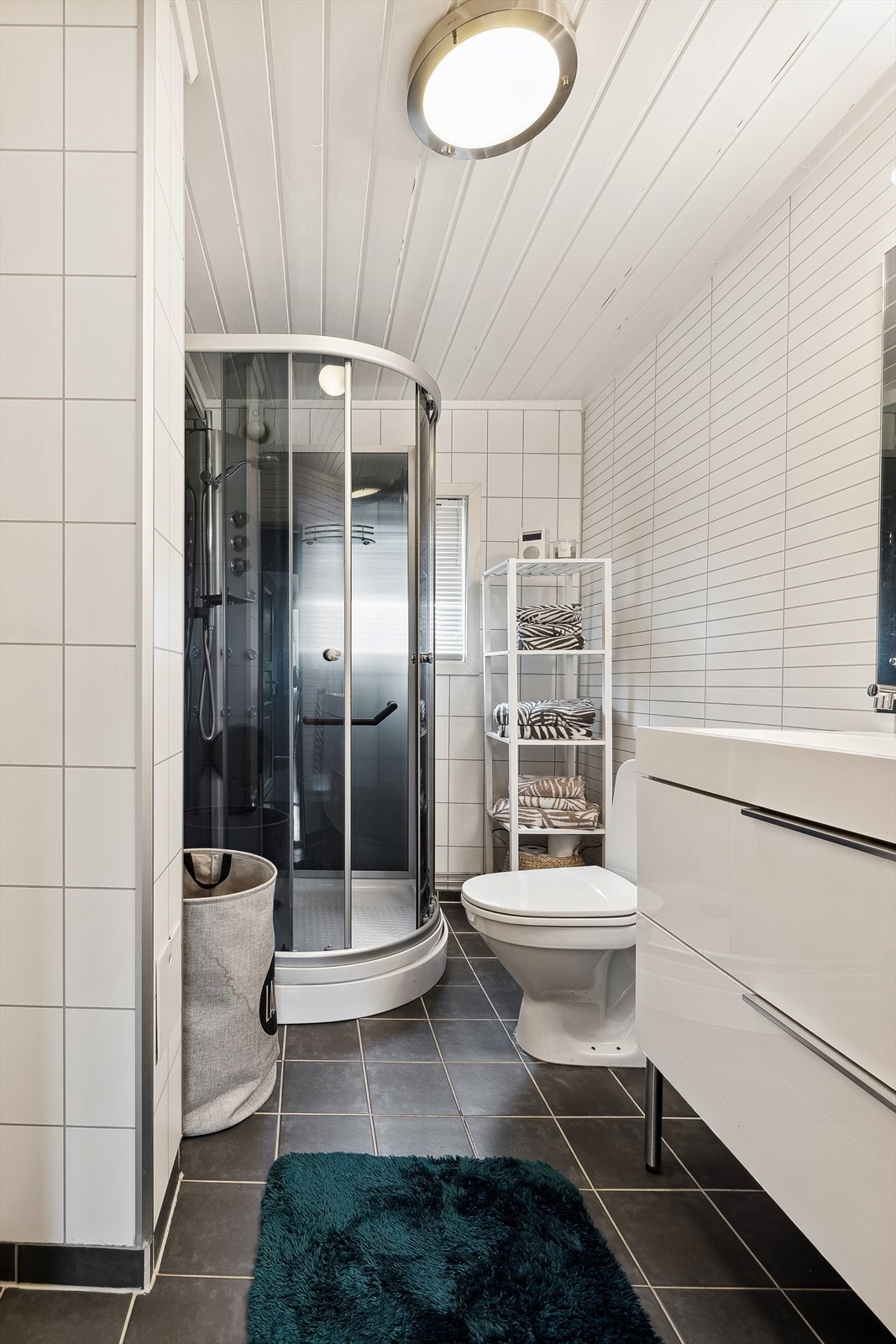 Badet er stilrent med flislagt gulv m/gulvvarme og baderomsplater på vegger Galleribilde
