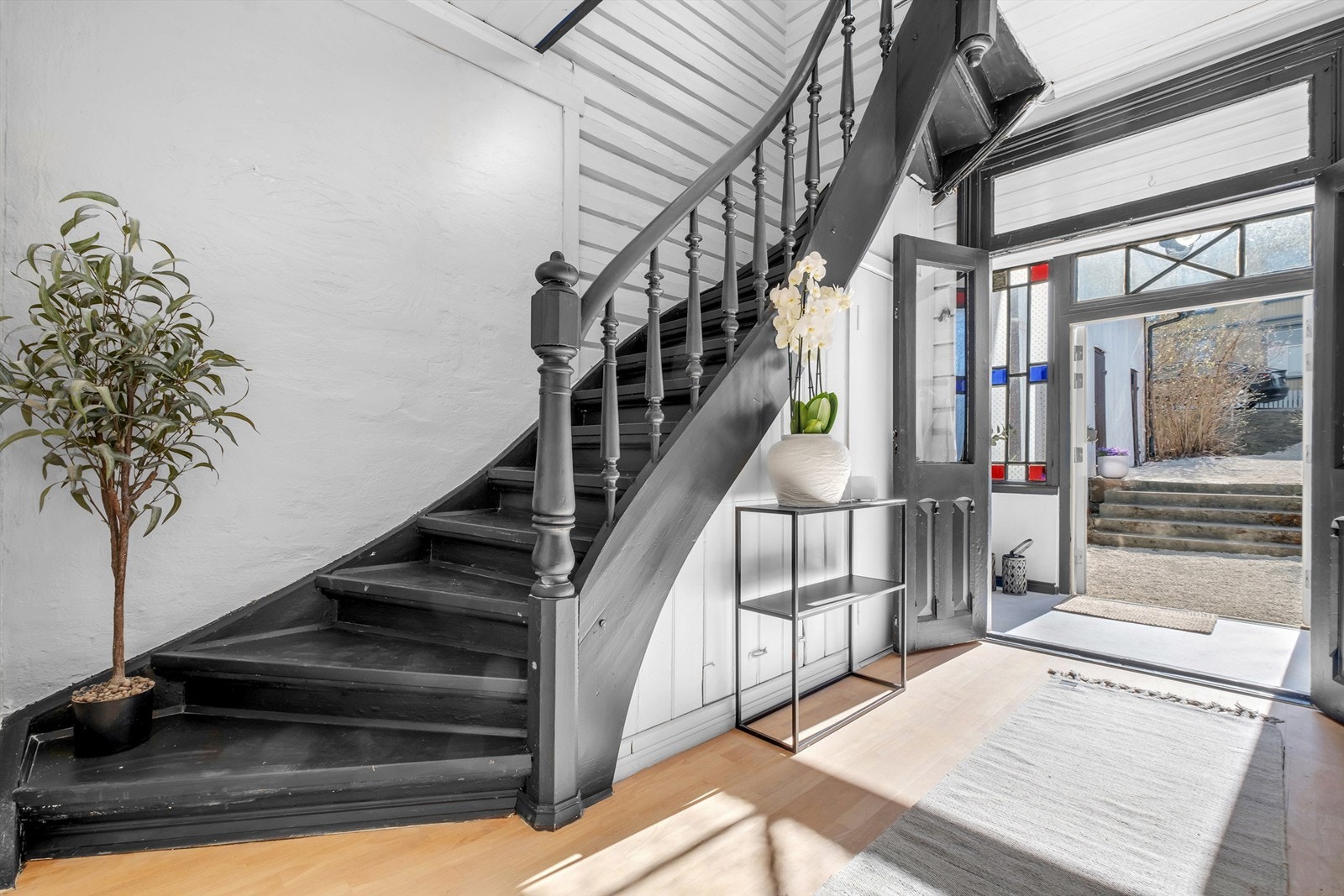 Under trappen finnes et intim toalettrom med blomstret tapet på veggene. Galleribilde