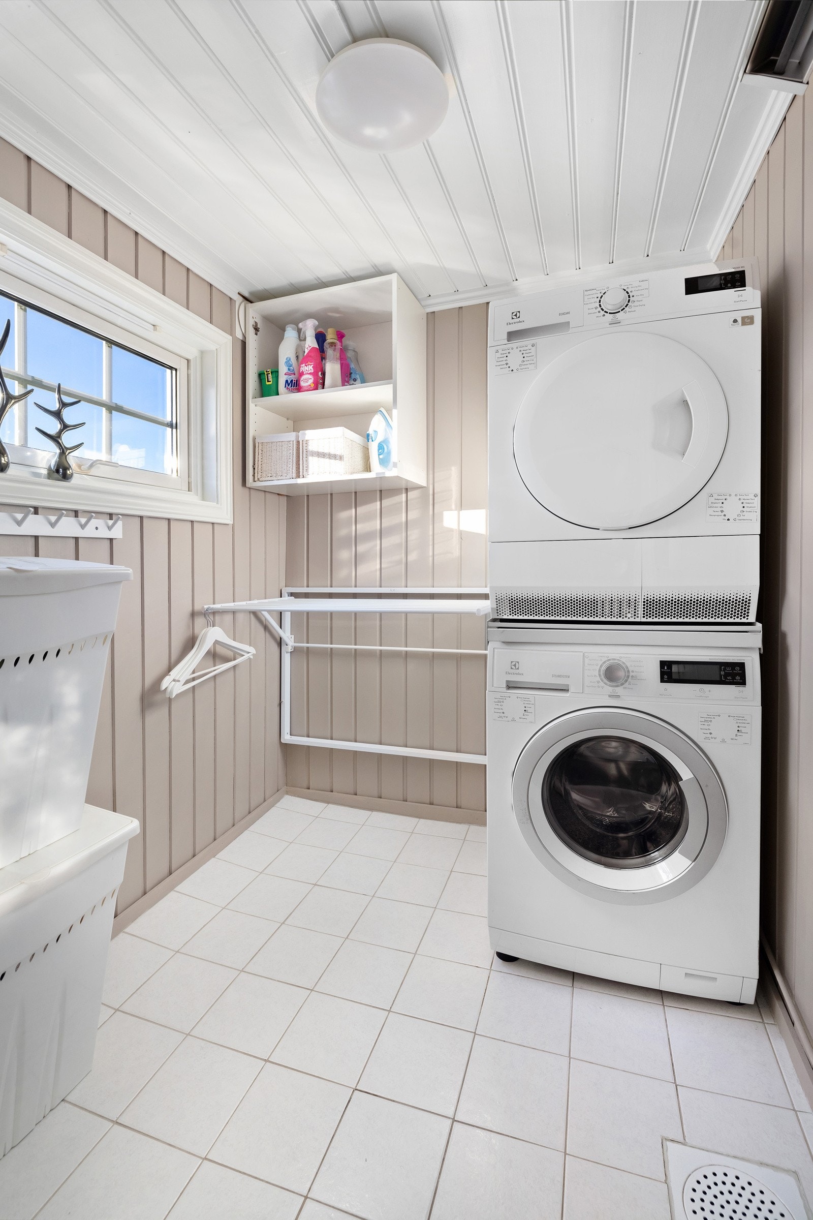 Vaskerommet er kjekt innredet med tørkesystem, hyller og opplegg for vaskesøyle. Galleribilde