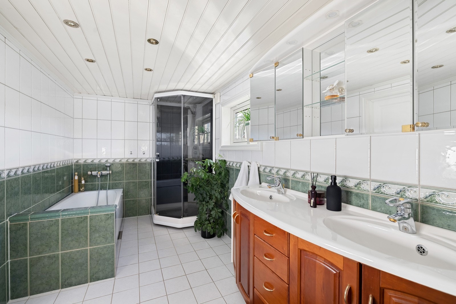 På badet er det dobbelservant, toalett, dusjkabinett og et innfliset badekar. Galleribilde