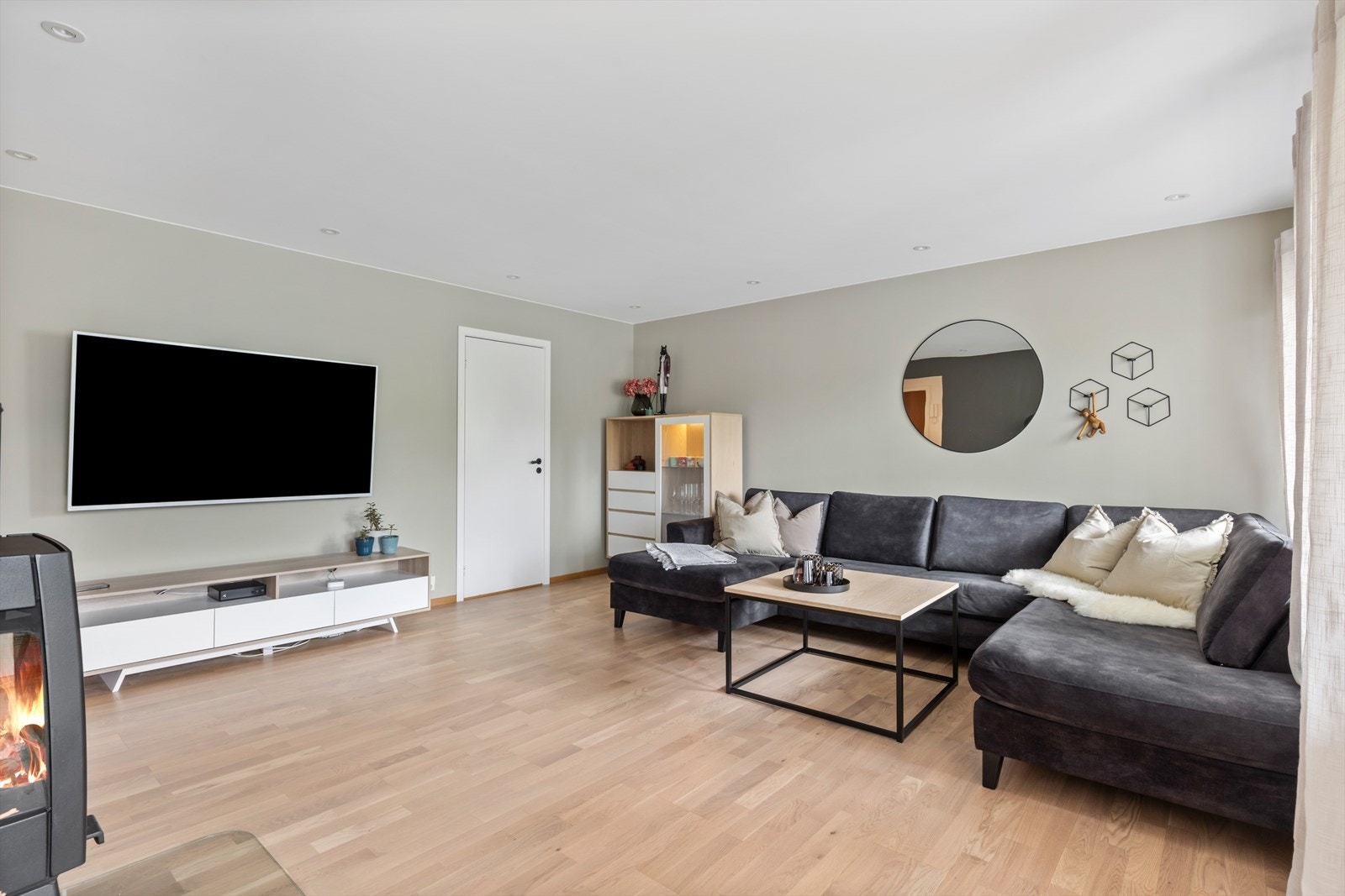 Stuen er holdt i moderne fargepaletter og oppleves lys og innbydende. Det er montert downlights i taket og alle vegger i slett utførelse. Galleribilde