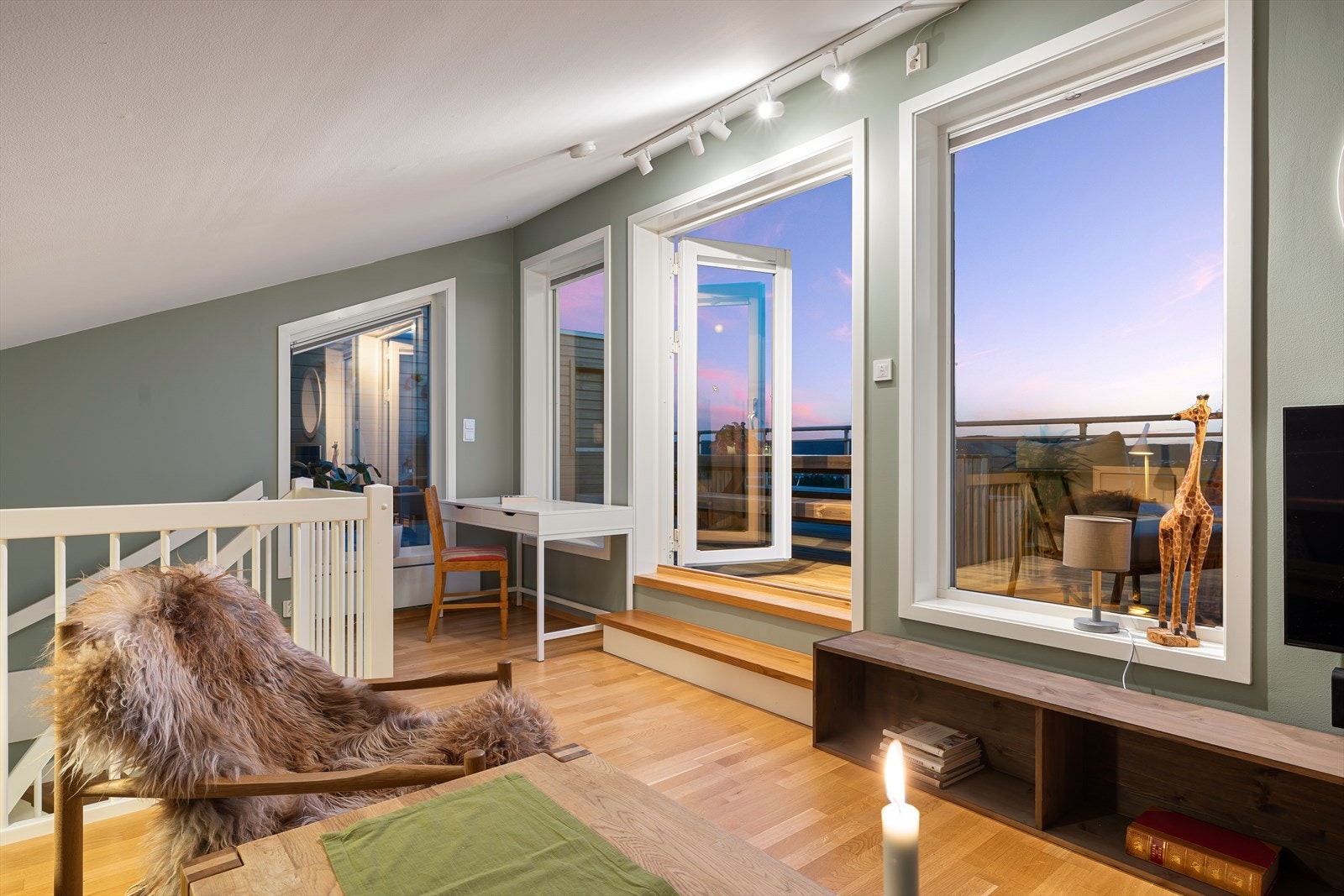 Stuen har skråhimling med ekstra takhøyde og utgang til en solfylt takterrasse med flott utsikt. I rommet er det plass til både kontorkrok og stor sofagruppe Galleribilde