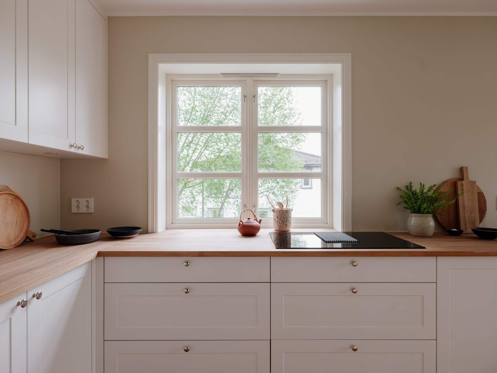 Påkostet kjøkkeninnredning fra Elen Møbelstudio. Lekker innredning i eik, med hvite profilerte fronter og heltre benkeplate. Dette er et kvalitetskjøkken Galleribilde