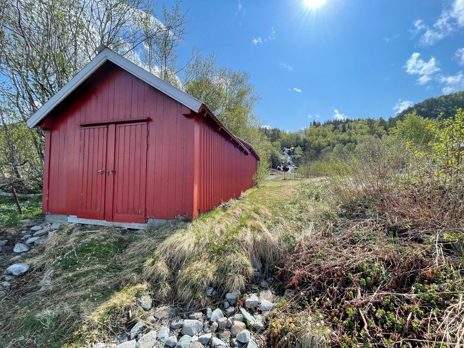 Naust som står på eiendommen, bildet er tatt fra vannkanten. Galleribilde