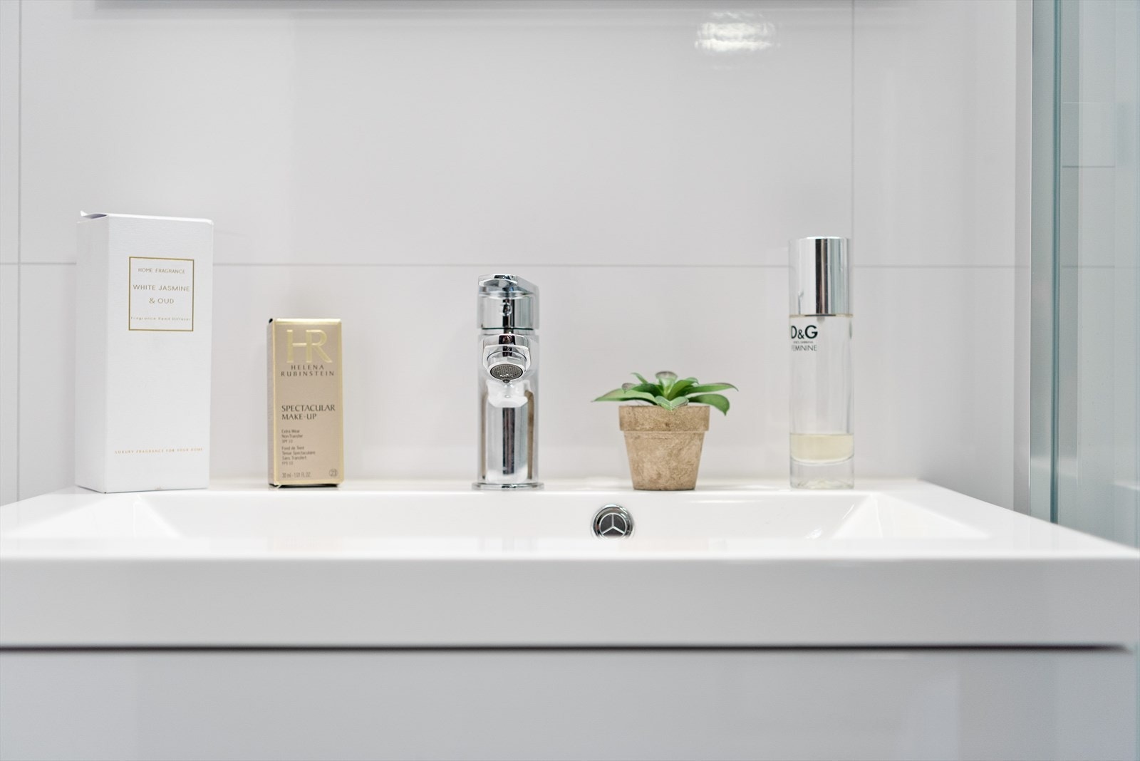 Baderomsinnredning av servant nedfelt i hvit innredning med to underskuffer og speilskap over. Galleribilde