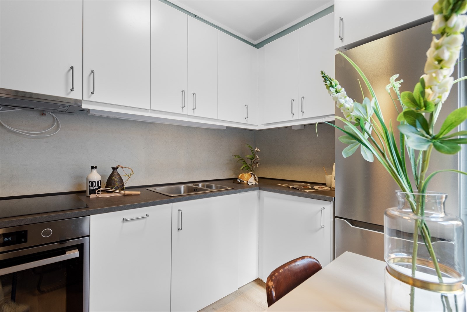 Kjøkkenet er et hyggelig rom med plass til spisebord ved vinduet. Nyere og tidløs innredning med lyse, slette fronter og godt med skapplass. Galleribilde