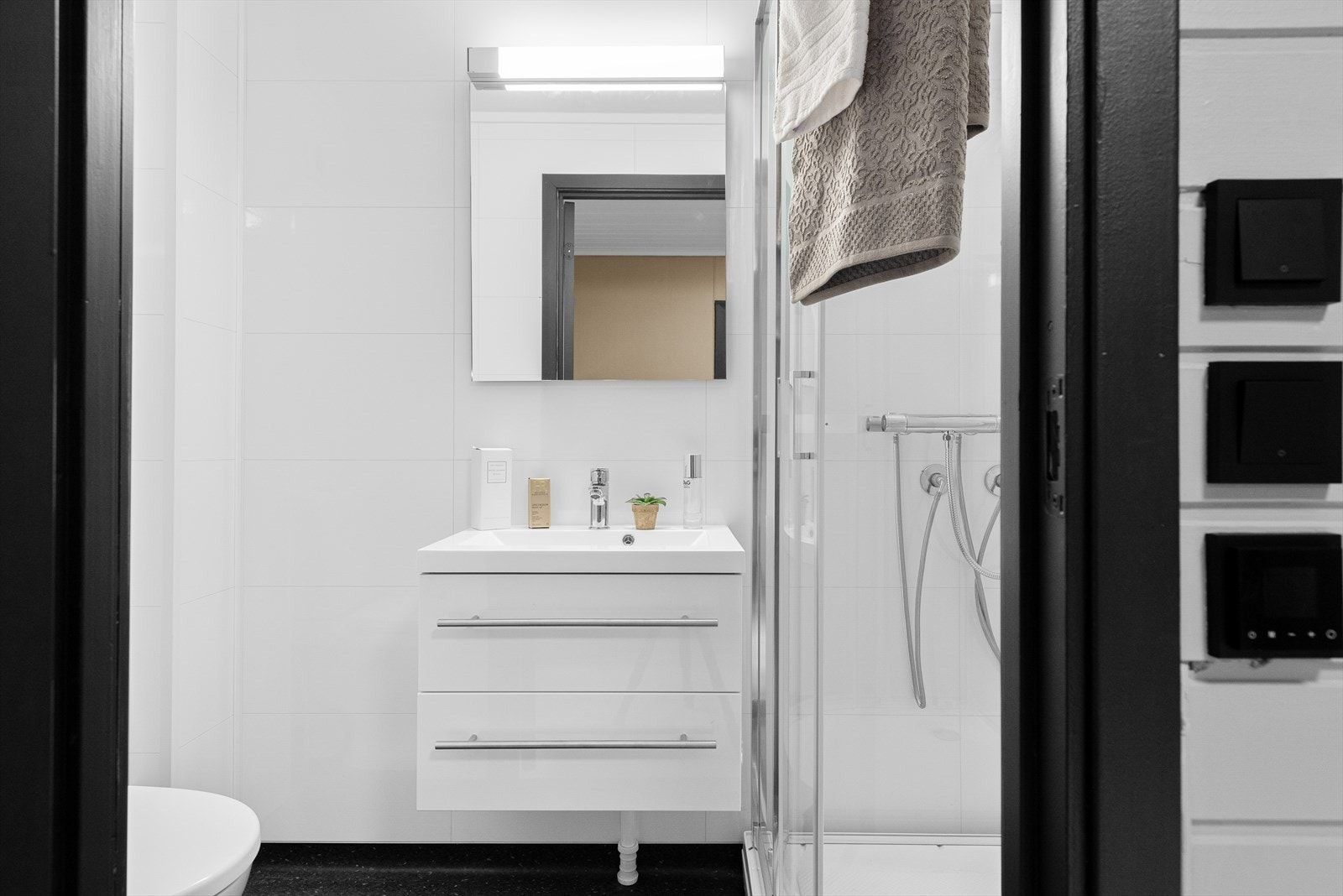 Det er overflater av belegg på gulv og hvite våtromsplater på vegger. Galleribilde