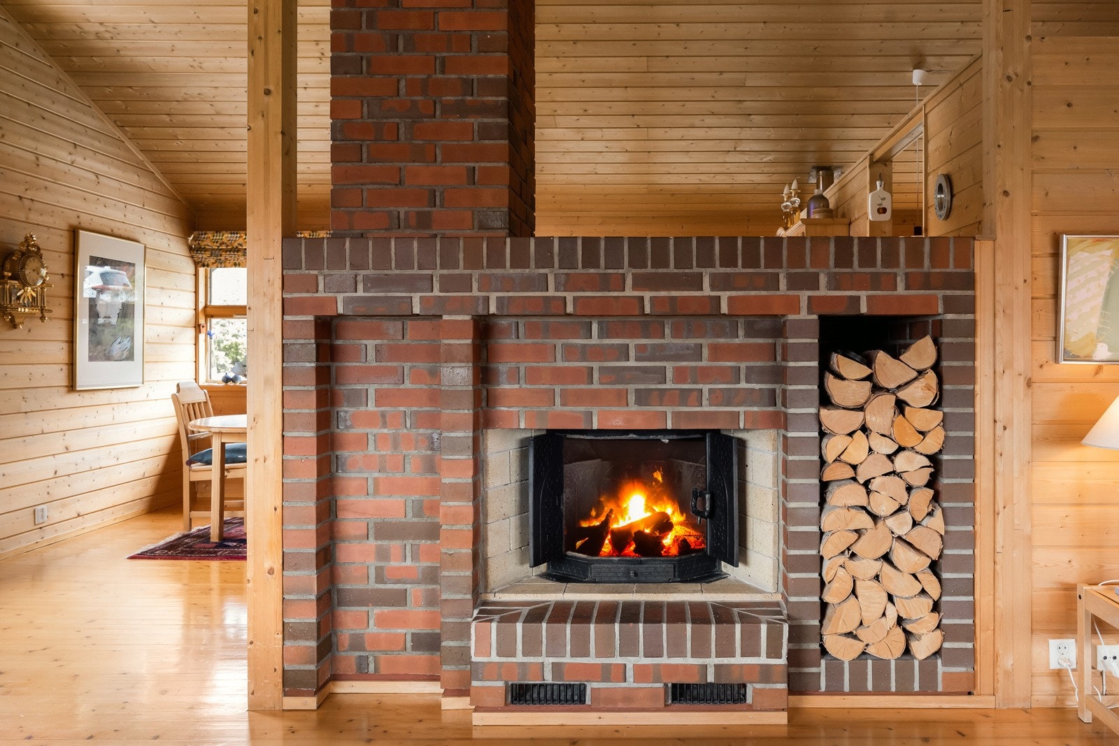 Flott teglsteinspeis som varmer godt på vinterhalvåret og deler dagligstuen og spisestuen. Galleribilde
