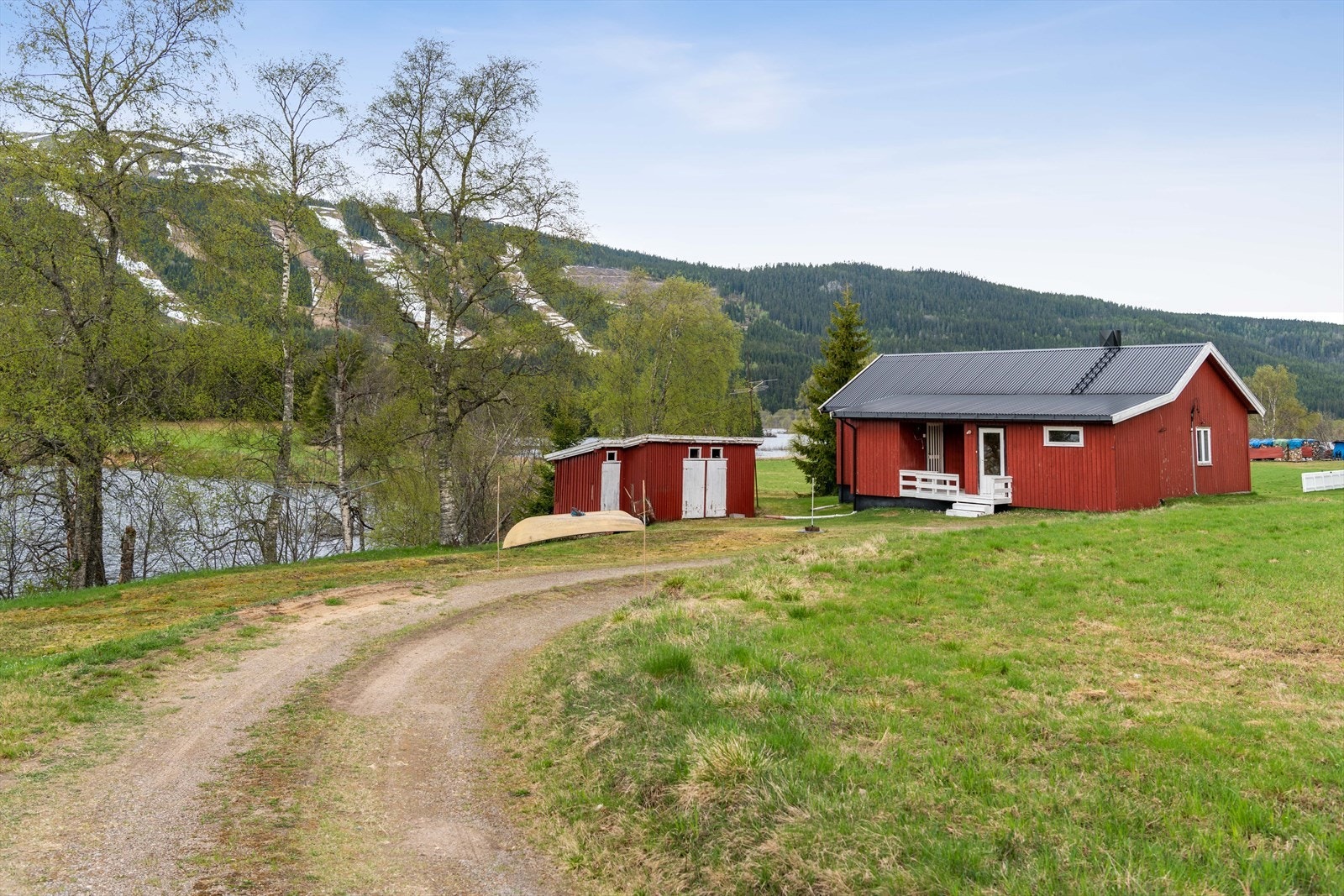 En solrik og landlig eiendom på ca. 1 070m² med idyllisk beliggenhet rett ved Trysilelva i Øverbygda, ca. 3 km nord for Trysil sentrum. Galleribilde