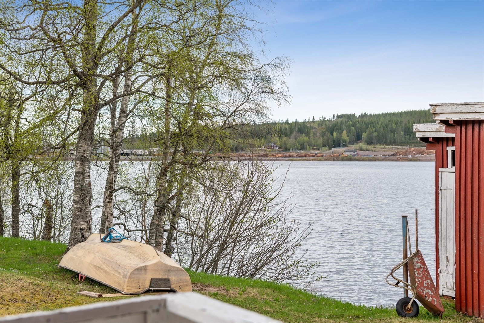 En relativt flat tomt med skråning ned til tomtegrense i Trysilelva ved Søndre Nesvika og utsikt mot Trysilfjellet. Galleribilde
