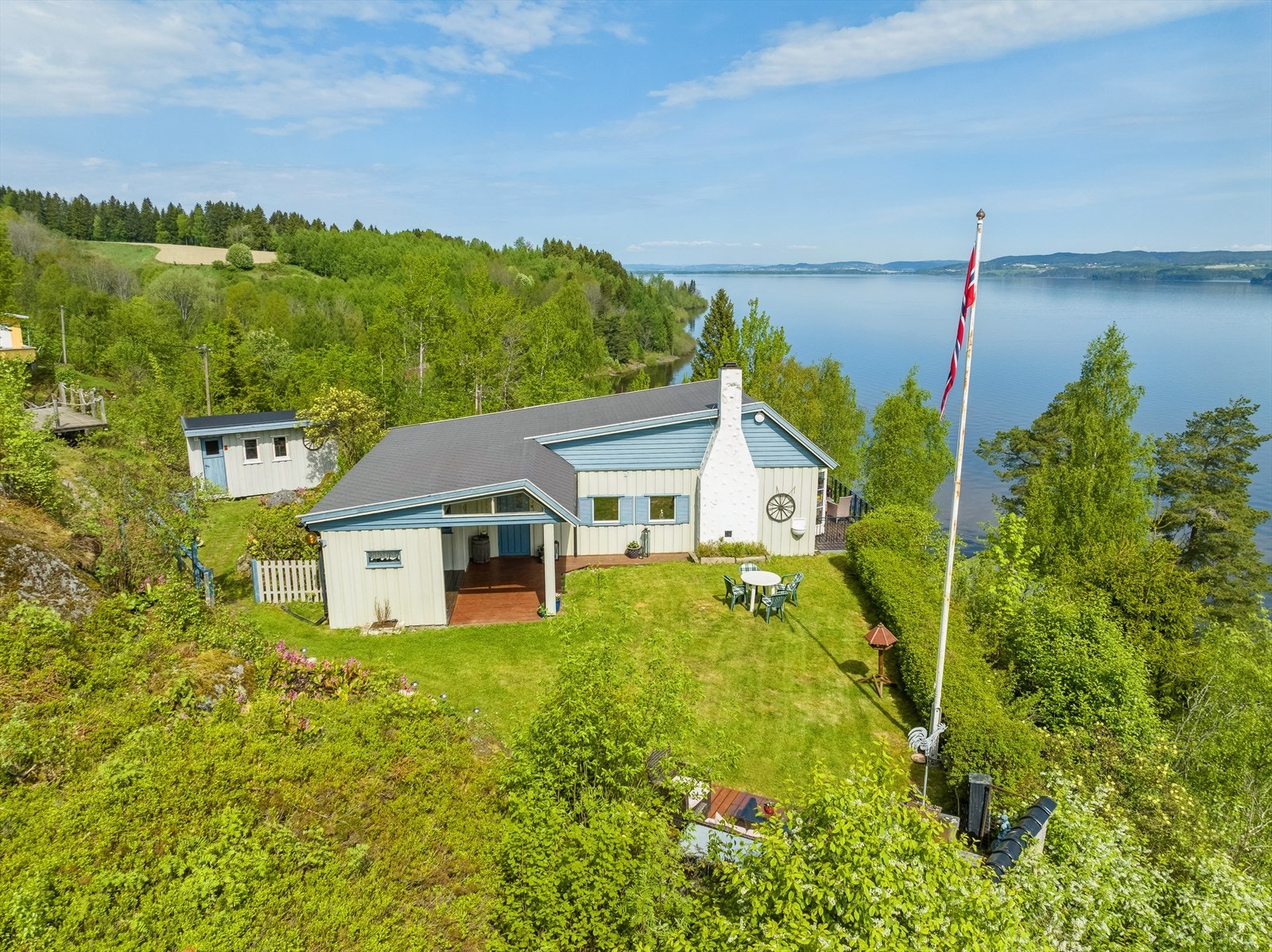 Eiendommen har en pent opparbeidet tomt med flott plenareal, naturtomt og beplanting Galleribilde