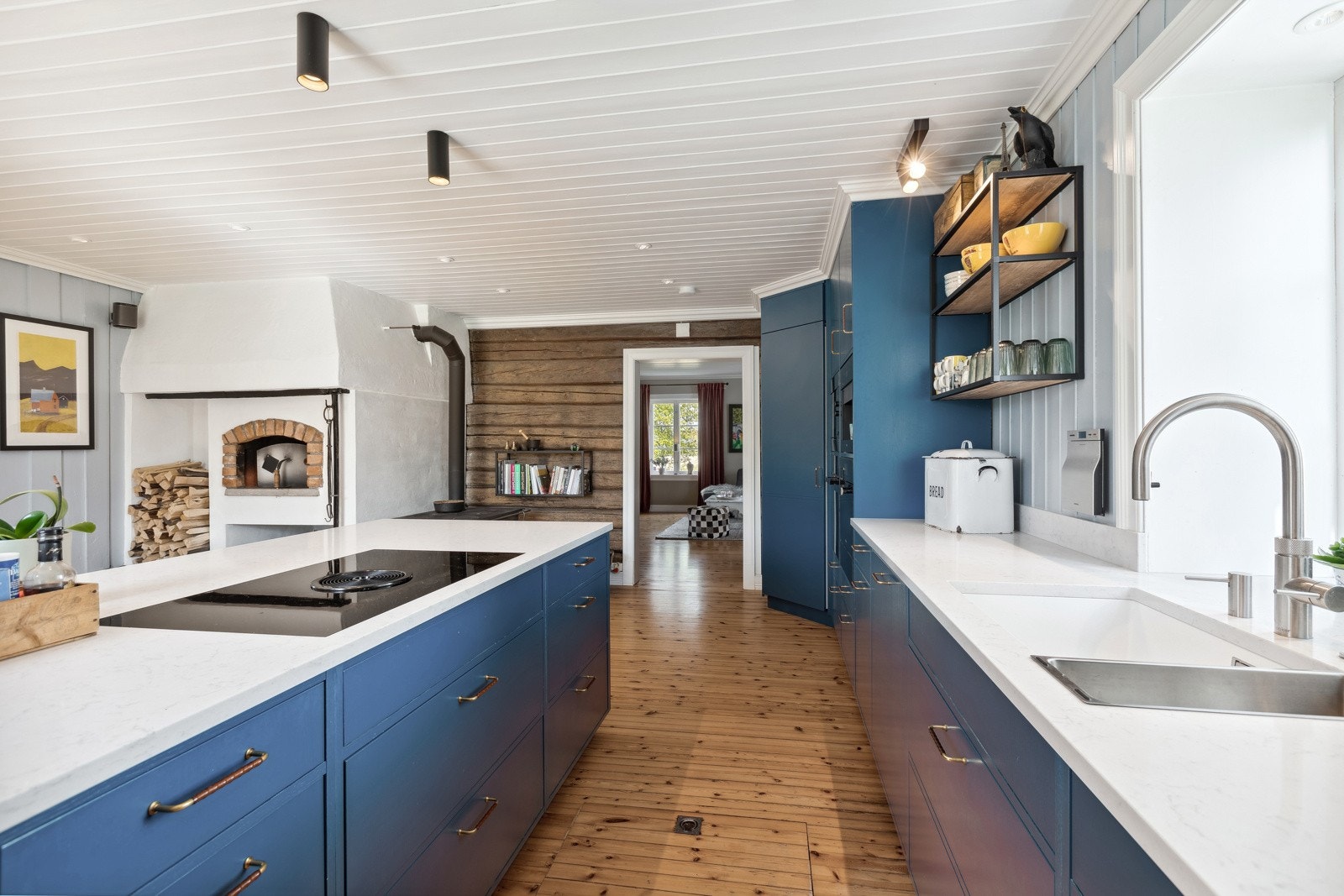 Kjøkkeninnredning med malte glatte fronter og benkeplate av stein. Galleribilde