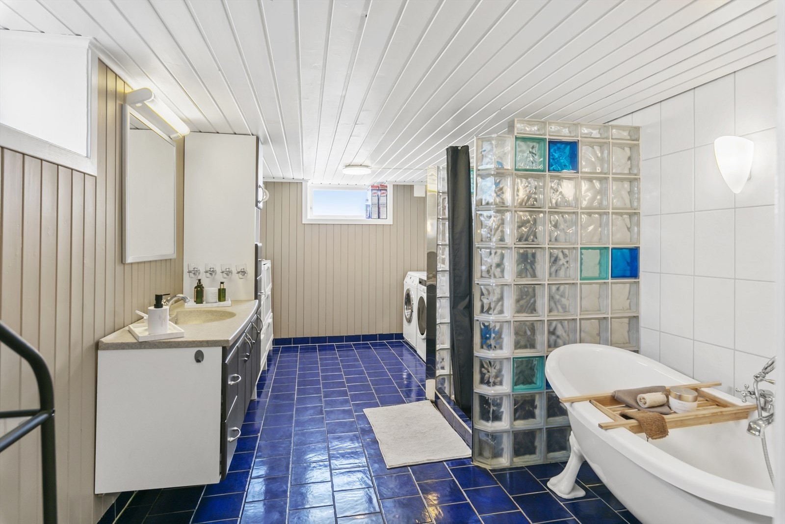 Baderommet er romslig har overflater av flis på gulv, samt flis og malt panel på. Galleribilde