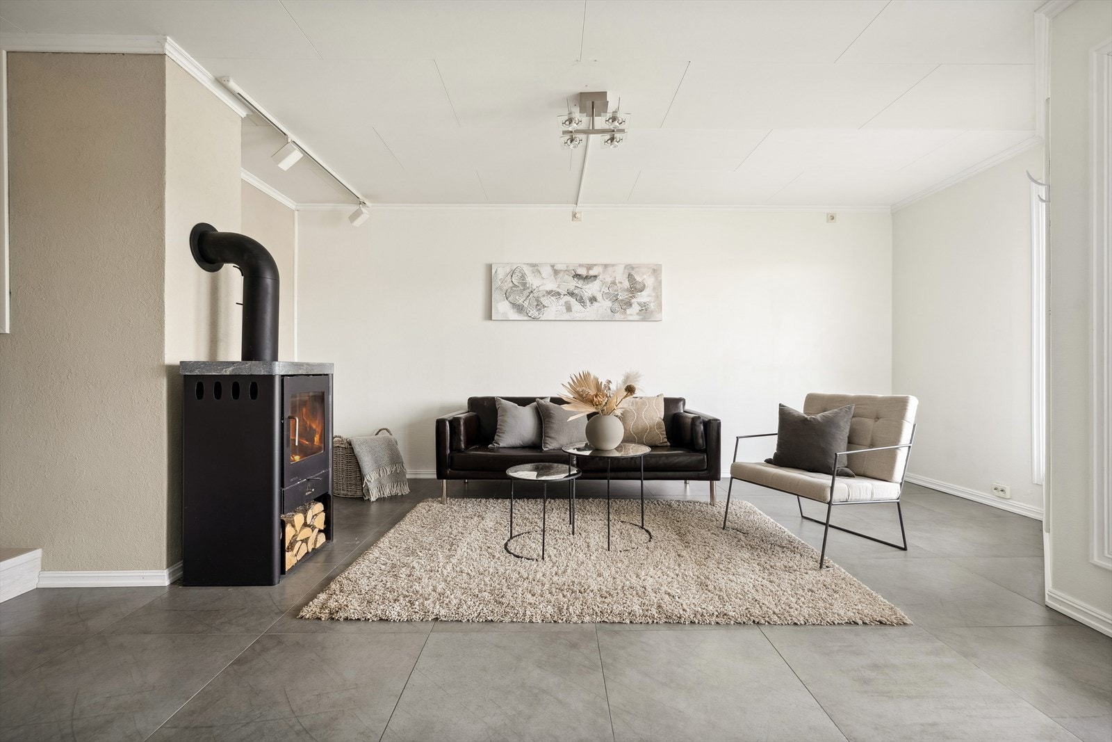 Rommet har fliser på gulv med varmekabler, vedovn og varmepumpe. Galleribilde