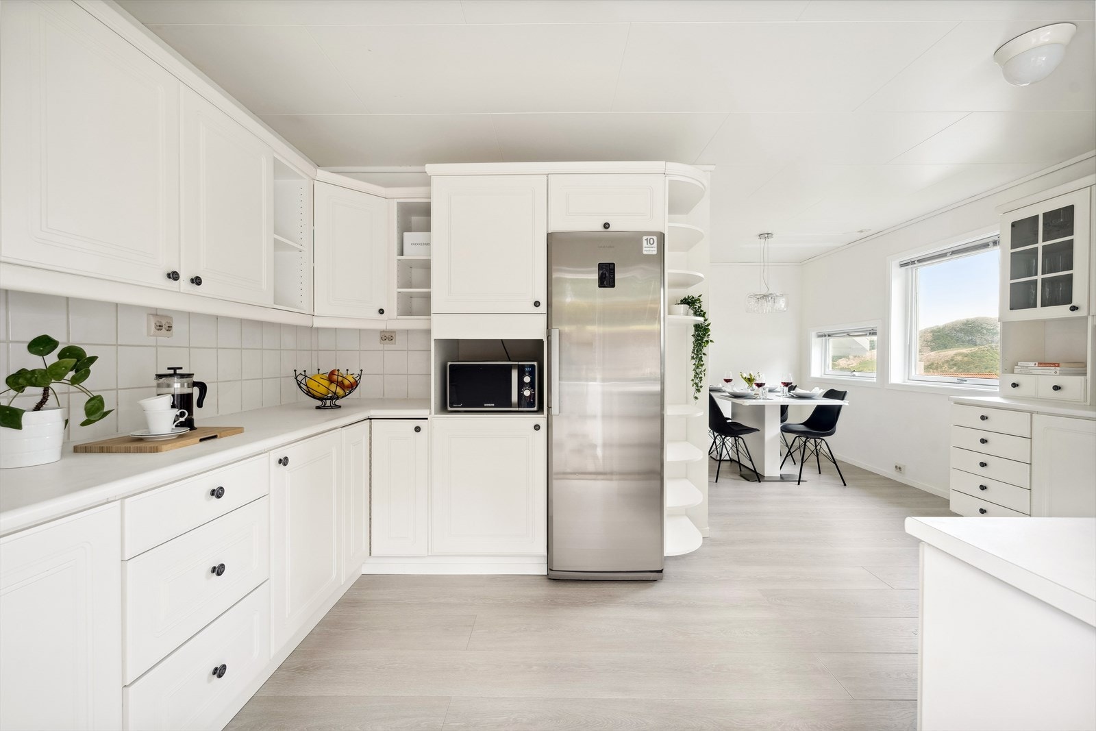 Kjøkkenet ligger adskilt fra stuen. Kjøkkeninnredningen har et tidløst design med hvite, profilerte fronter, og laminat benkeplate med oppvaskkum i stål. Galleribilde