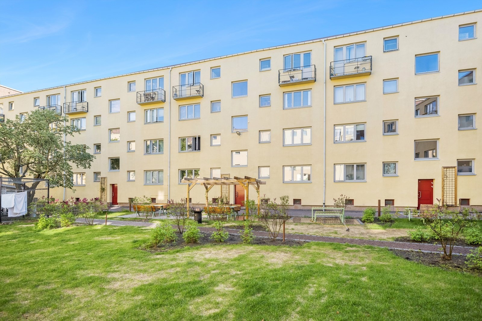 Byggets fasade sett fra uteområdet. Beboerne har tilgang til låsbar sykkelbod, fellesvaskeri og gjesteleilighet. Galleribilde