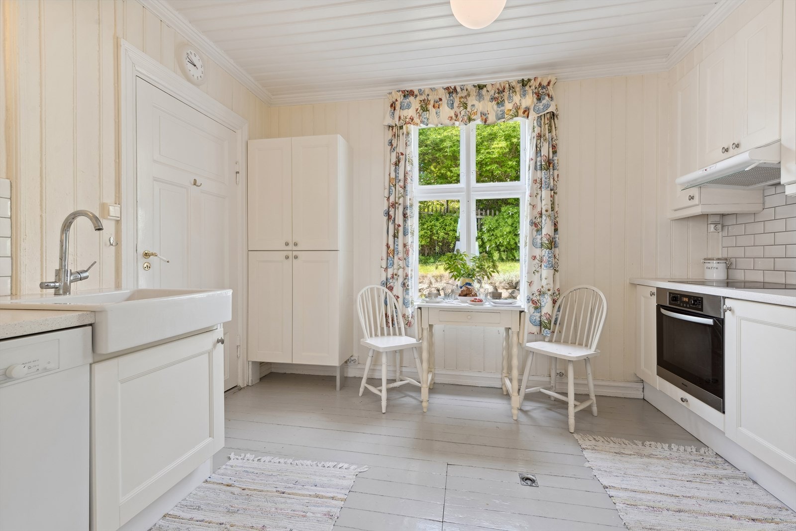 Stort spisekjøkken innenfor spisestuen. Døren til venstre fører ut til inngangspartiet. Ventilator, stekeovn og keramisk topp er integrert i innredningen. Opplegg for oppvaskmaskin. Kjøkkeninnredning fra 2010. Galleribilde