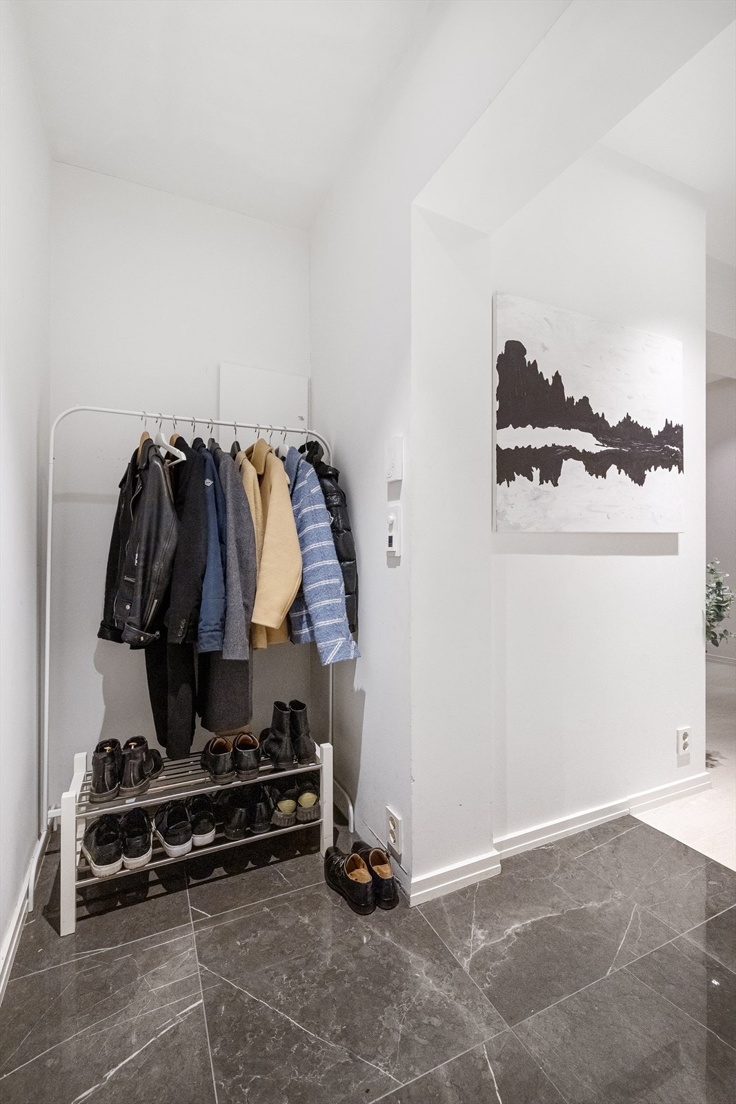 Flislagt entré med varmematte under flis og plass til oppheng av yttertøy og sko. Galleribilde