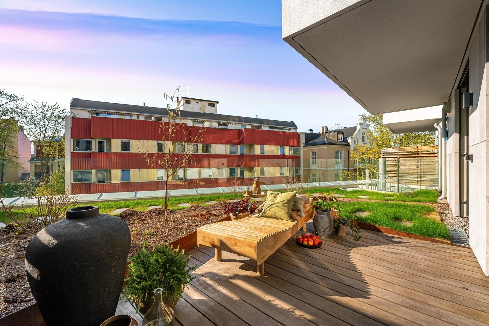 Der terrassebordene slutter er det overgang til en privat og deilig takhage med plen, heller, tre og glassrekkverk i enden. Galleribilde