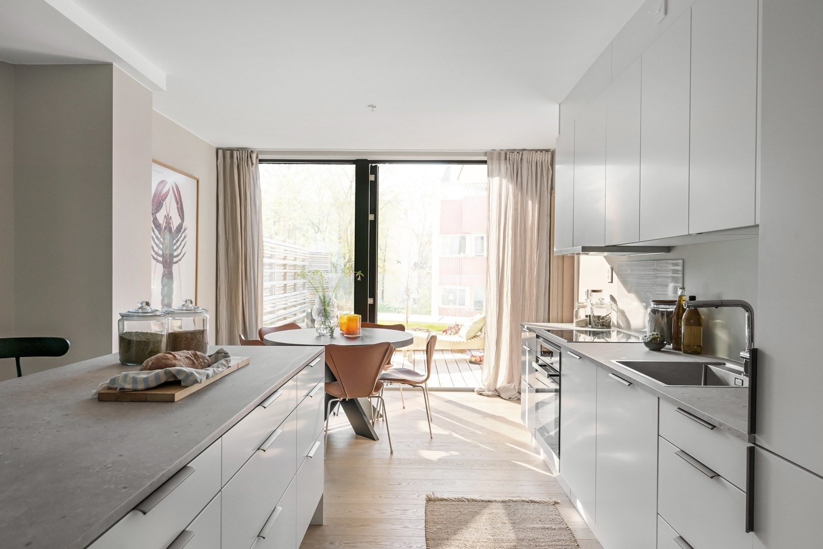 Integrert i innredningen har kjøkkenet induksjonstopp, stekeovn, oppvaskmaskin og kjøl/frys. Det er montert glassplate bak induksjonstopp og avtrekk er via balansert anlegg. Galleribilde