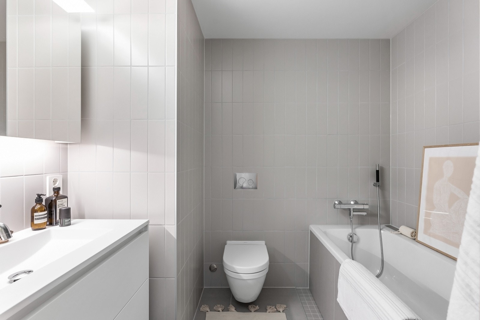 Innredningen er montert i nisje og har hvite, glatte skuffefronter, heldekkende servant og speilskap med belysning. Galleribilde