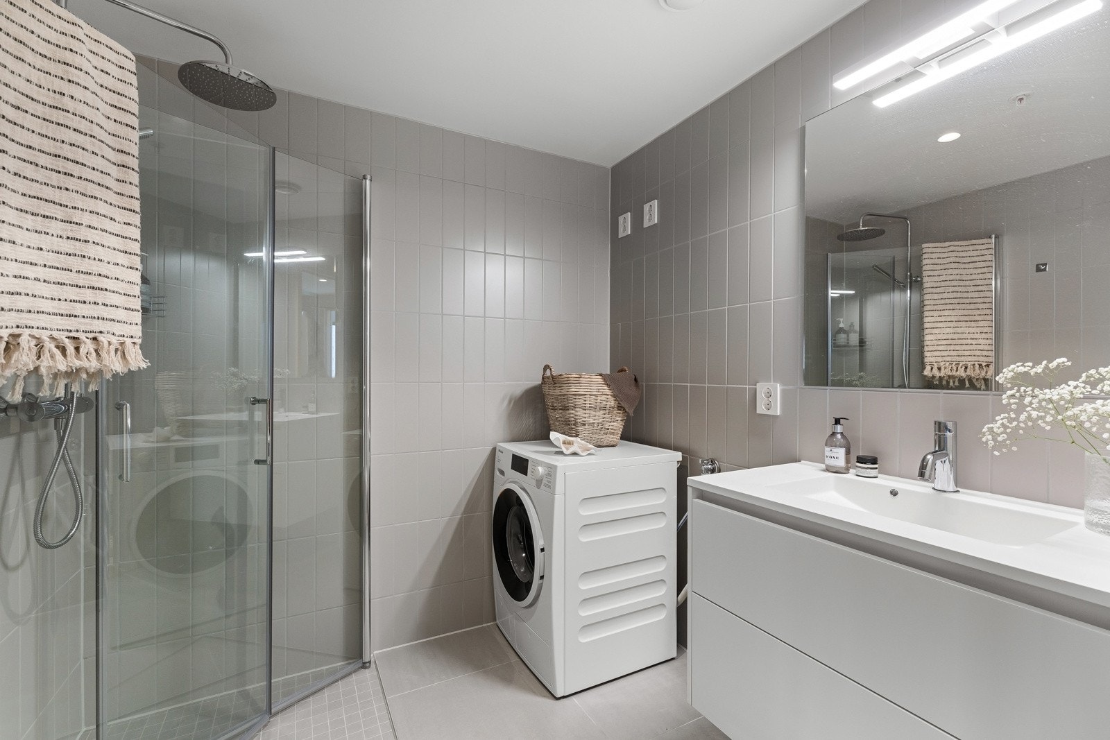 Begge badene er holdt i samme stil med flislagte overflater, gulvvarme, downlights og avtrekk via balansert ventilasjon. Galleribilde