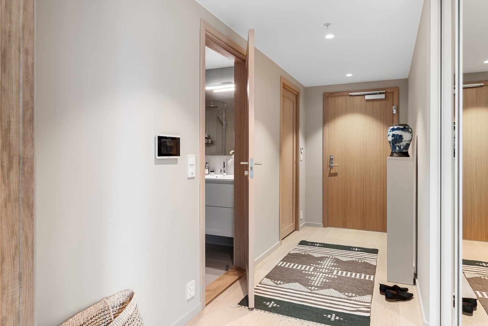 Leiligheten ligger i fjerde etasje og har inngang til en innbydende entré med enstavs parkettgulv, spotlights i himling og vegger malt i en klassisk, rolig fargetone. Både ytterdøren og innvendige dører er i flott heltre eik. Galleribilde