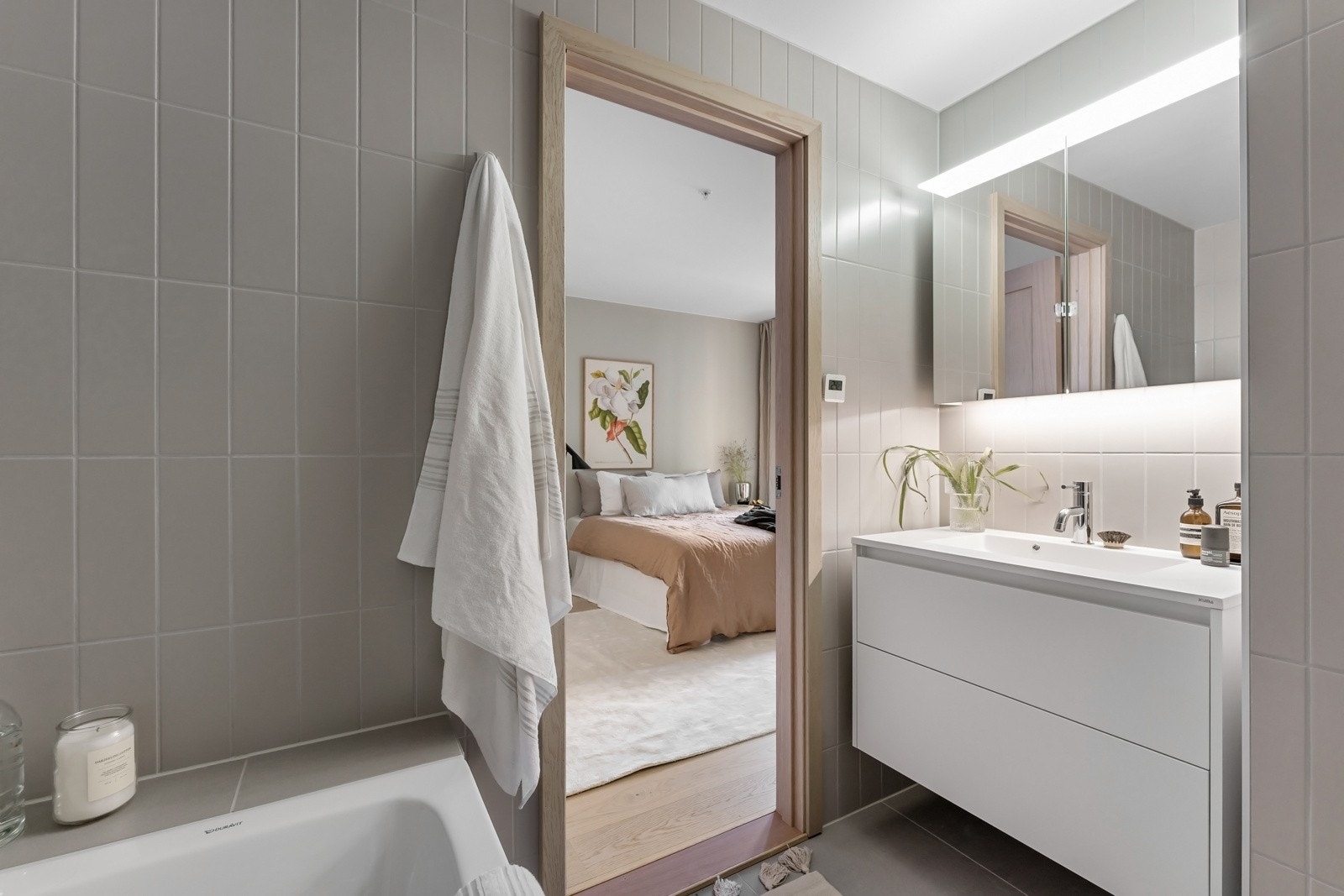 Badet har samme stilmessige uttrykk som badet tilknyttet entreen og er utstyrt med både veggmontert toalett, et innmurt badekar og dusjgarnityr montert på veggen. Galleribilde