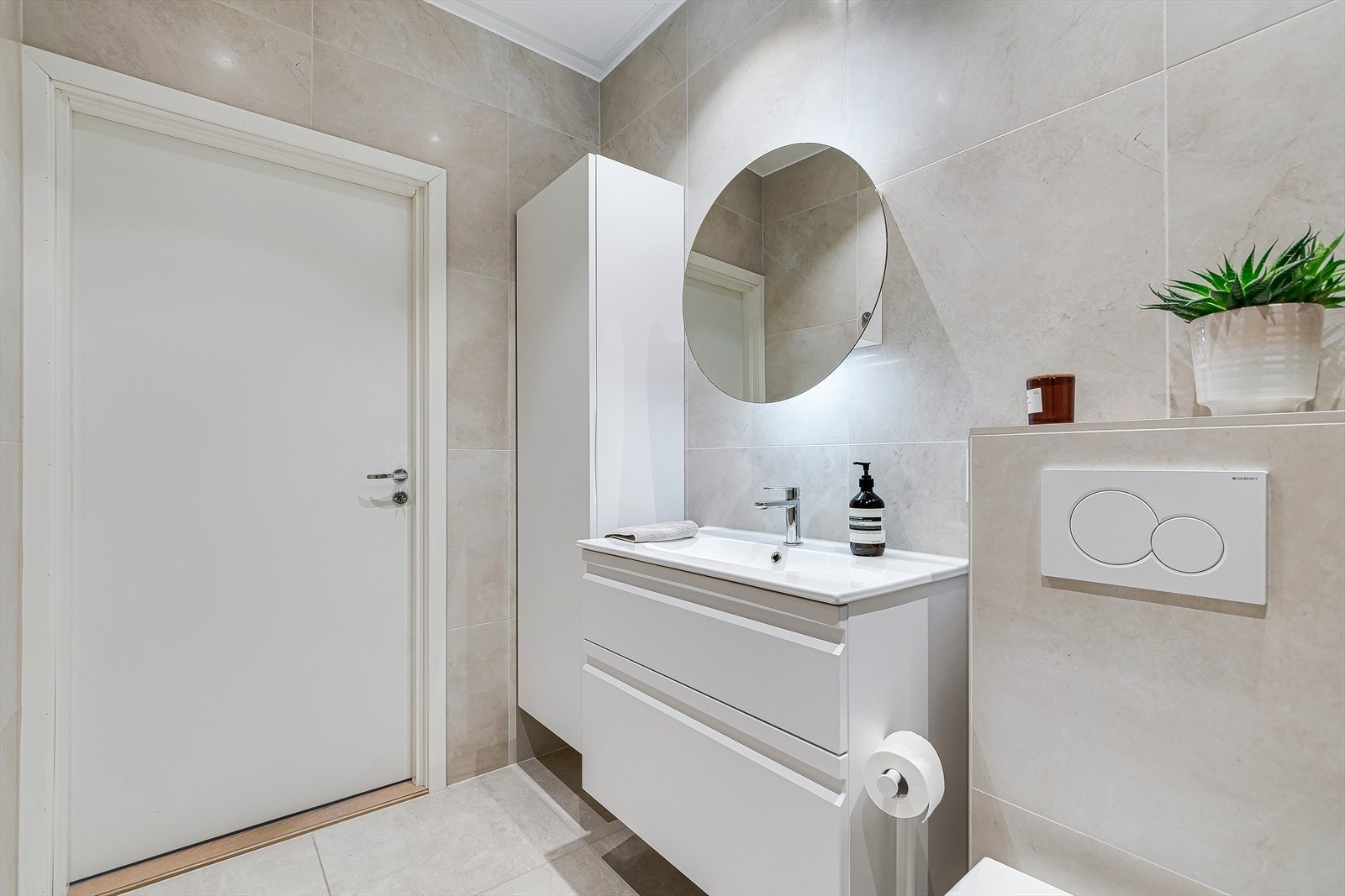 Badet har god plass til oppbevaring med høyskap, bredt servantskap og speil med hylle. Galleribilde