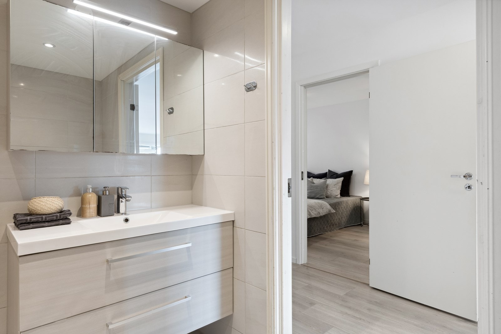 Innredning med slette fronter og heldekkende servant med 1-greps blandebatteri og avløpsrør av plast. Opplegg for vaskemaskin. Vegghengt toalett. Galleribilde