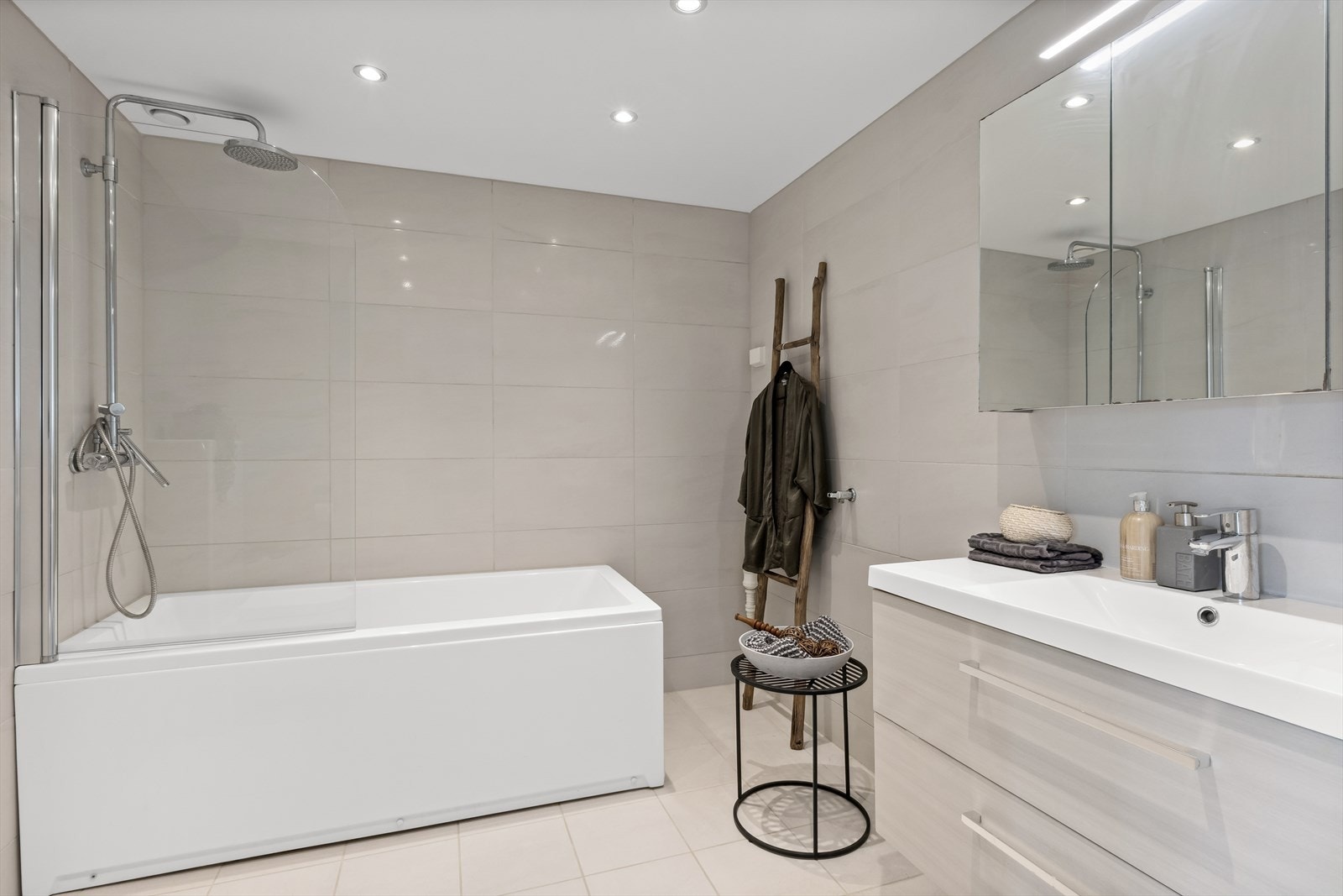 Flislagte vegger og himling med downlights. Badekar med 1 stk svingbare glassvegg og 2- greps blandebatteri. Galleribilde