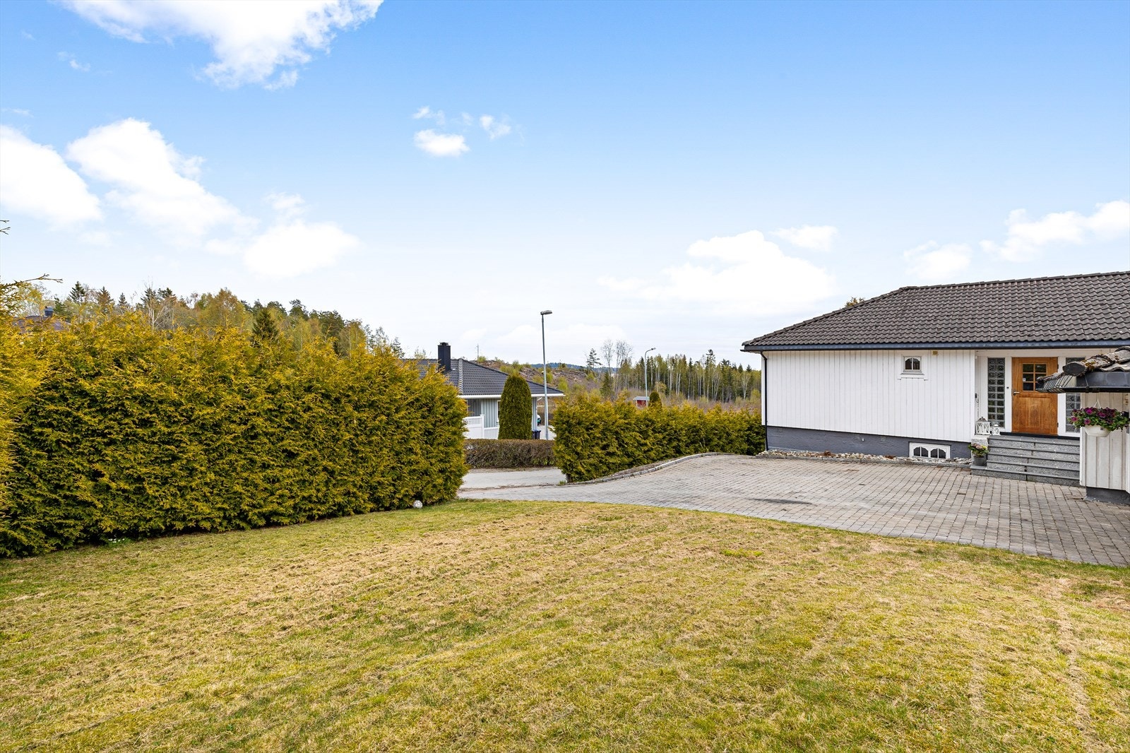 Tomten er pent opparbeidet med frodig hekk som skjermer for innsyn. Videre er det store områder med gressplen med god plass til lek og moro. Galleribilde