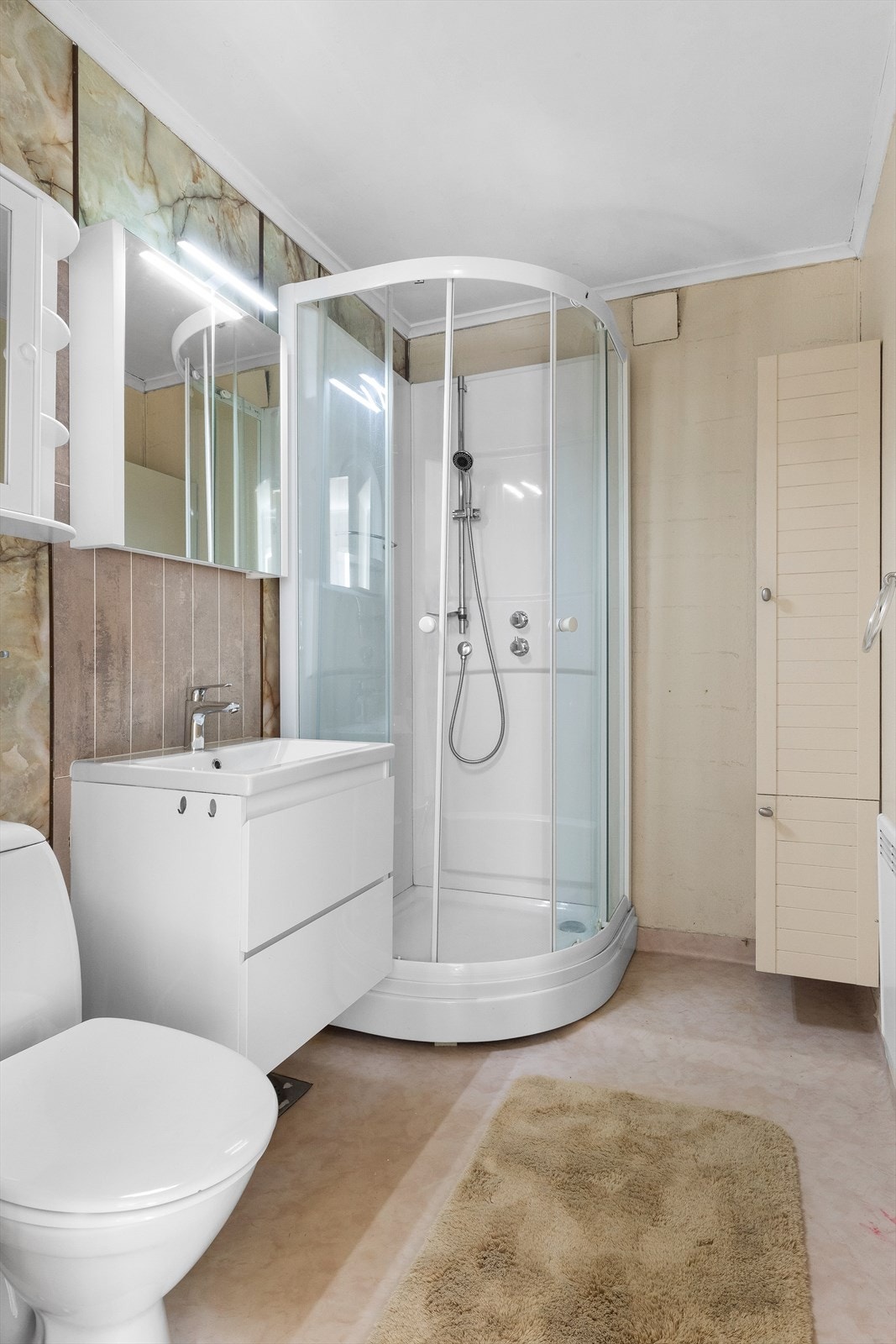 Badet inneholder dusjkabinett, toalett og seksjon m/servant. Galleribilde