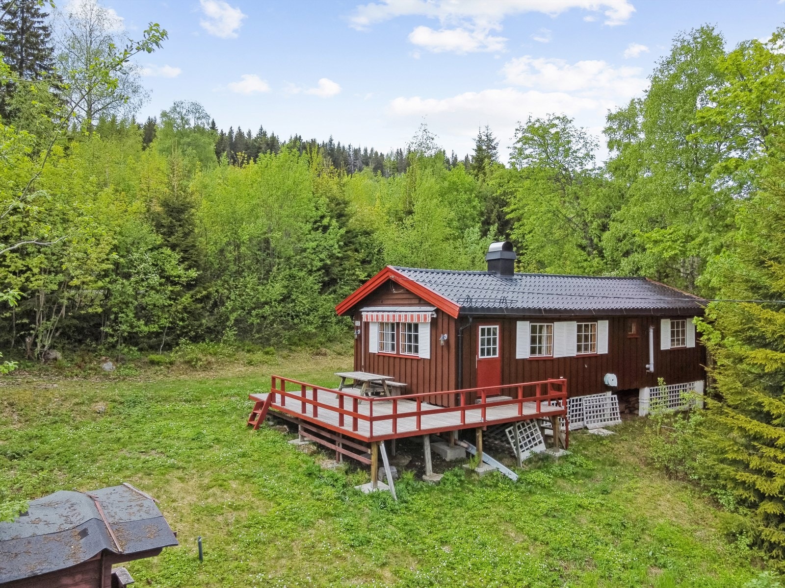 Tomten er lett skrånende og opparbeidet med gressplen og naturtomt. Galleribilde