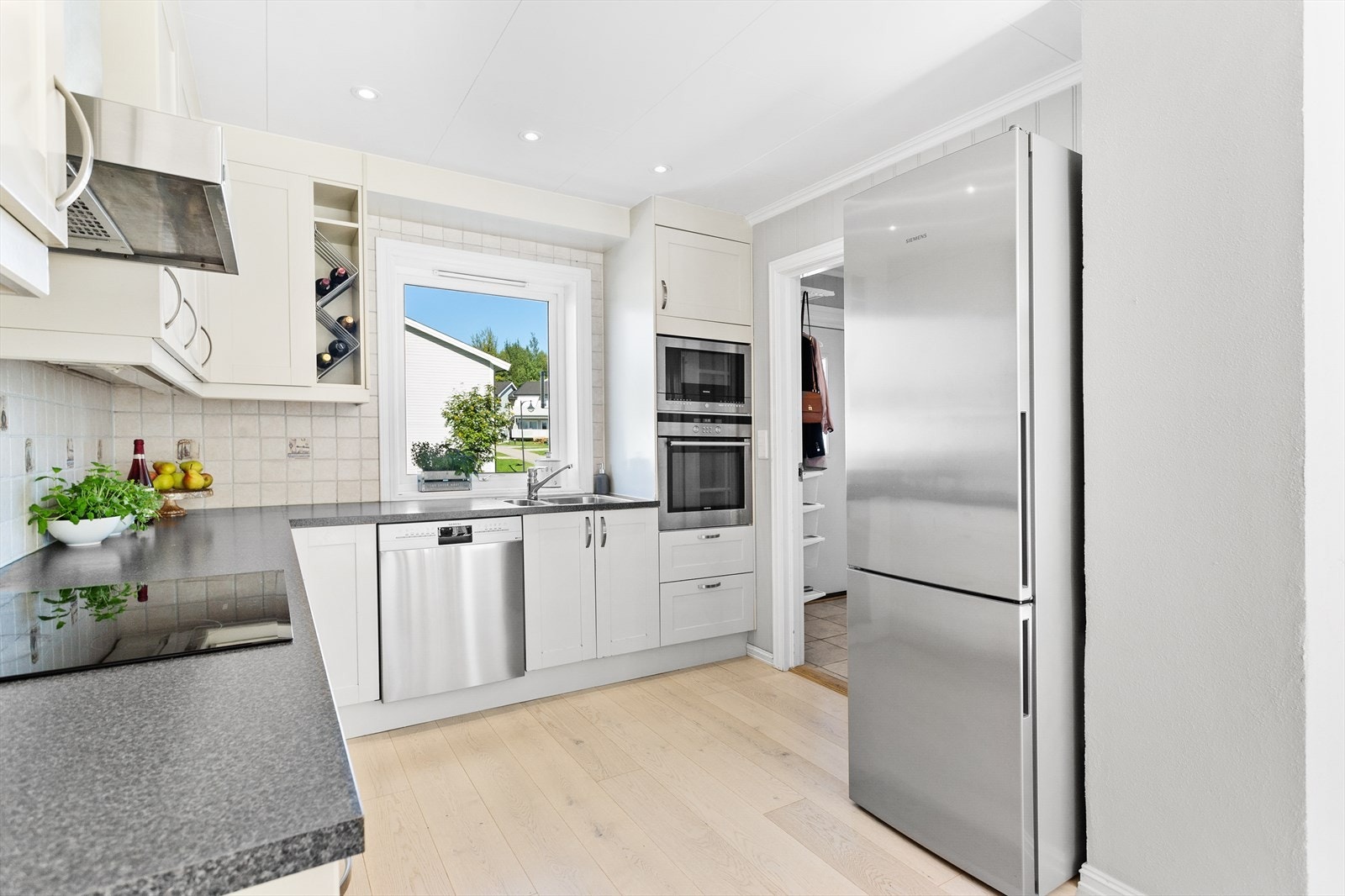 Innredningen består av profilerte fronter, laminat benkeplate og stålhåndtak. Galleribilde