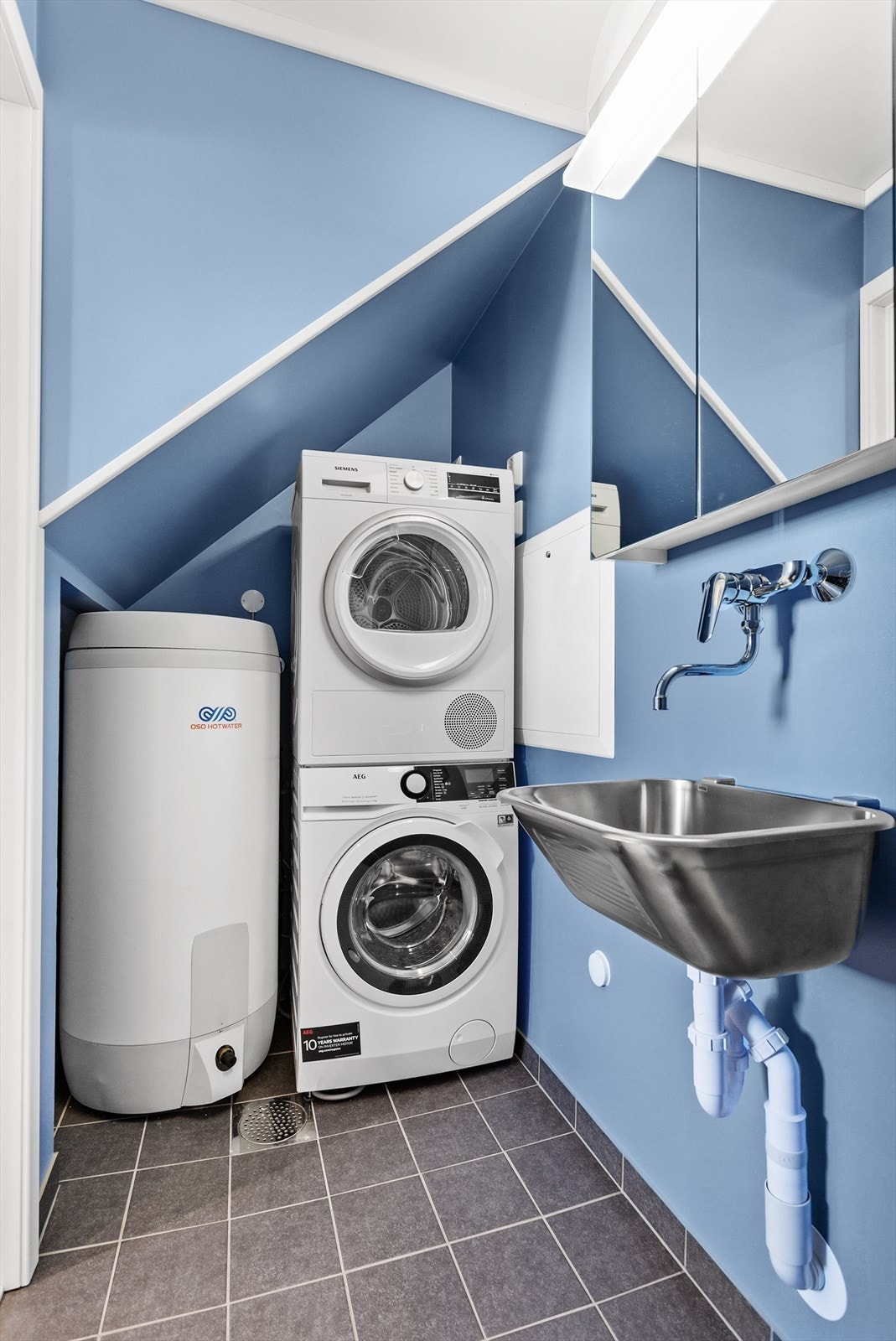 Pent bad-/vaskerom med flislagt gulv og malte overflater. Tilgang til varmtvannsbereder og mulighet for tørketrommel. Galleribilde