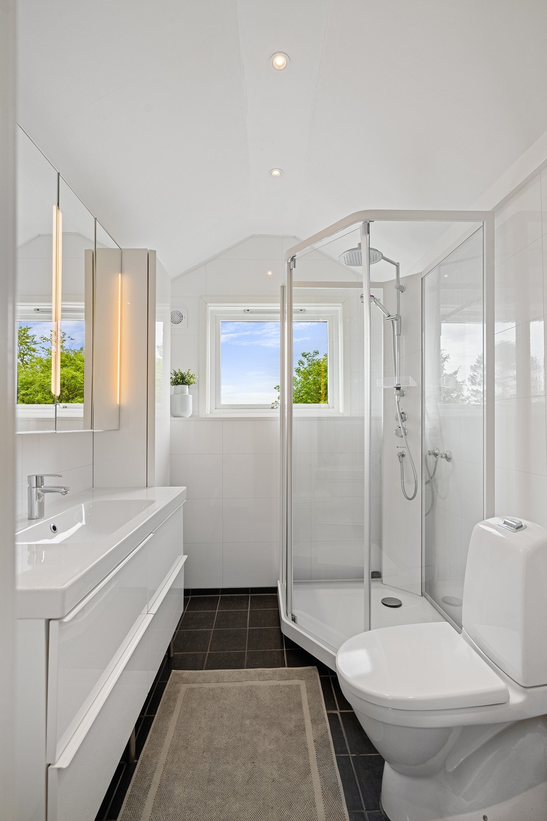 Flott bad innredet med toalett, vask i servantskap og dusjkabinett. Galleribilde