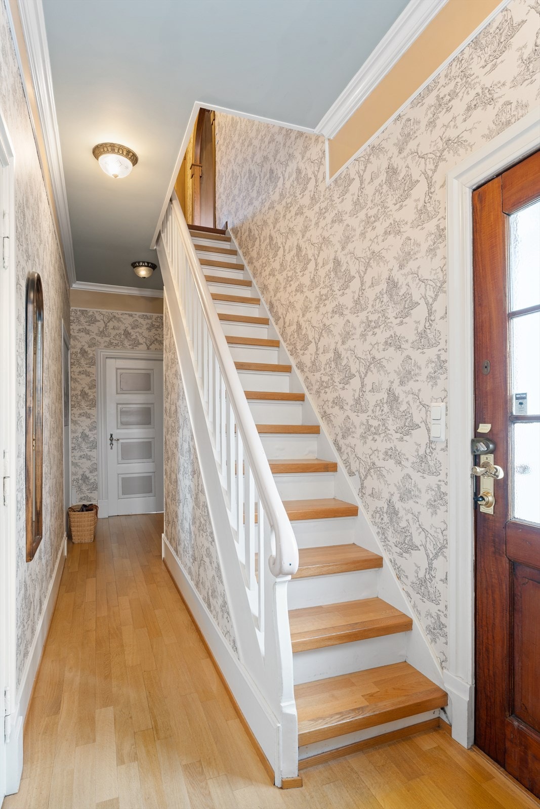 Fra kjøkkeninngangen/bi-inngangen kommer man inn i en bakgang. Herfra fører dører inn til kjøkkenet, spisestuen, hallen og underetasjen.Trappeløp opp til 2. etg Galleribilde