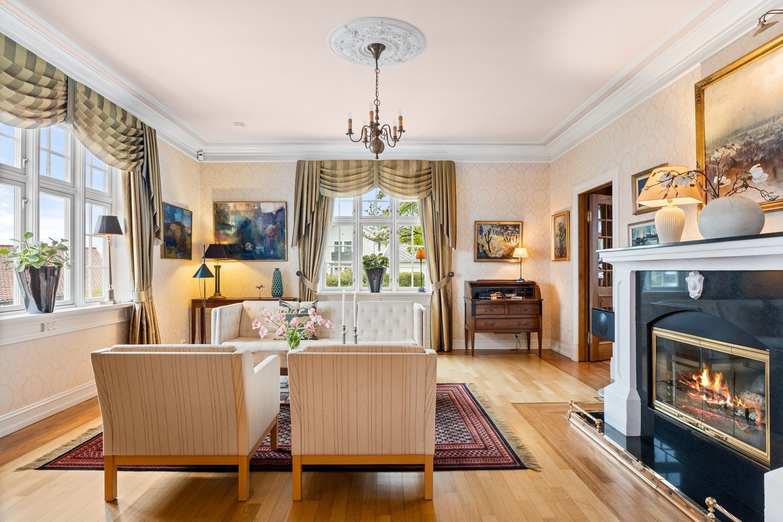 Peisestuen har store vinduer som slipper inn mye dagslys. Flott engelsk peis Galleribilde