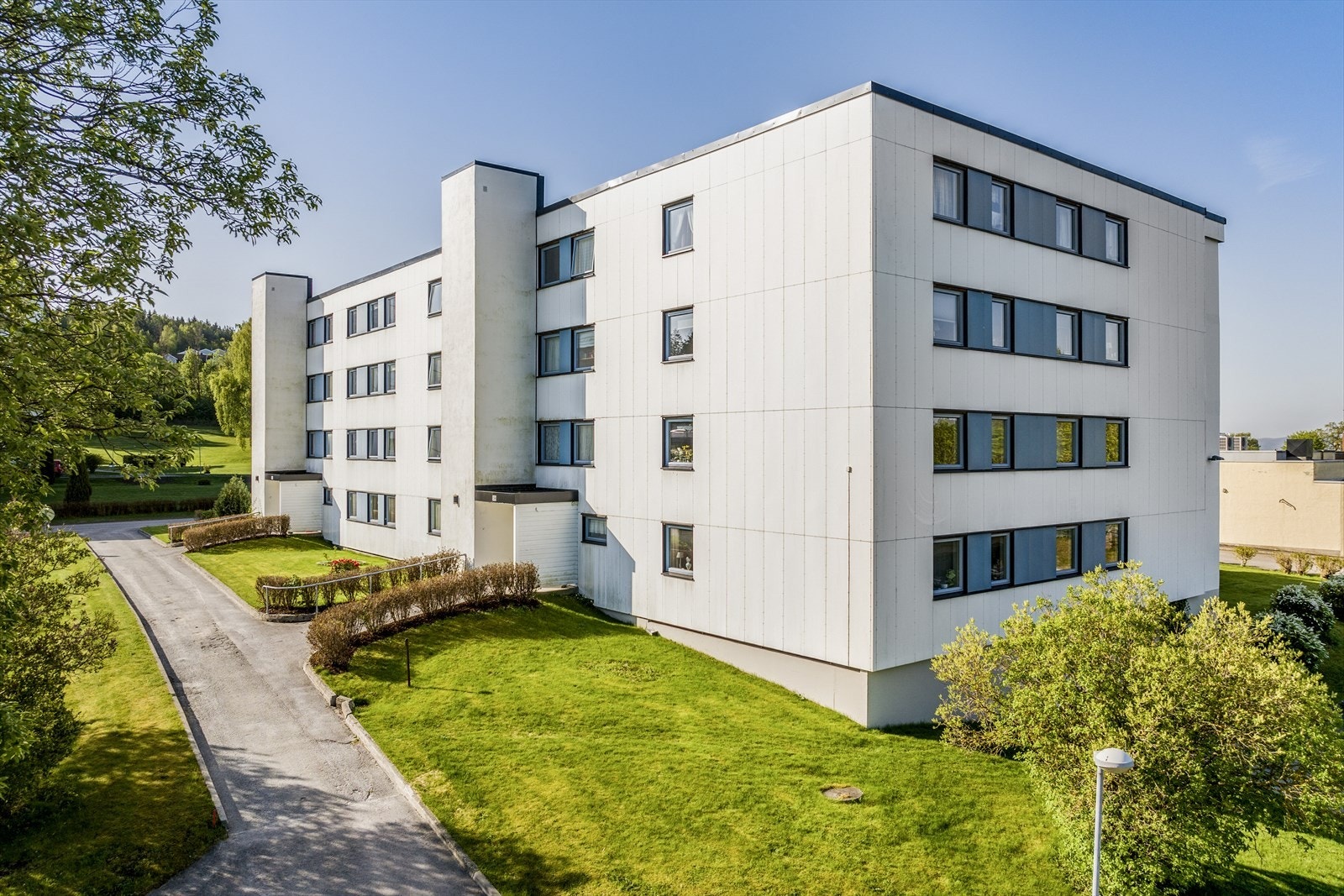 Tomten er opparbeidet med fint vedlikeholdte fellesområder med prydbusker, sittegrupper, parkeringsplasser mm. Galleribilde