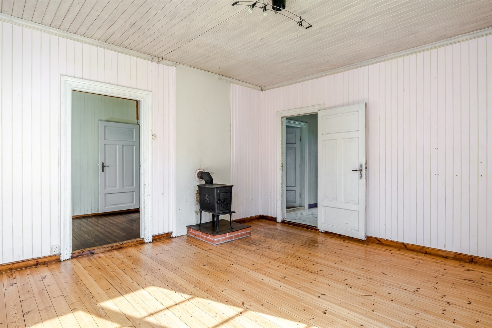 Stuen blir oppvarmet med vedovn montert på en murt forhøyning og panelovner montert på vegg. Fra stuen har man adkomst inn til soverommet som man kan benytte som spisestue og ut i gangen. Galleribilde